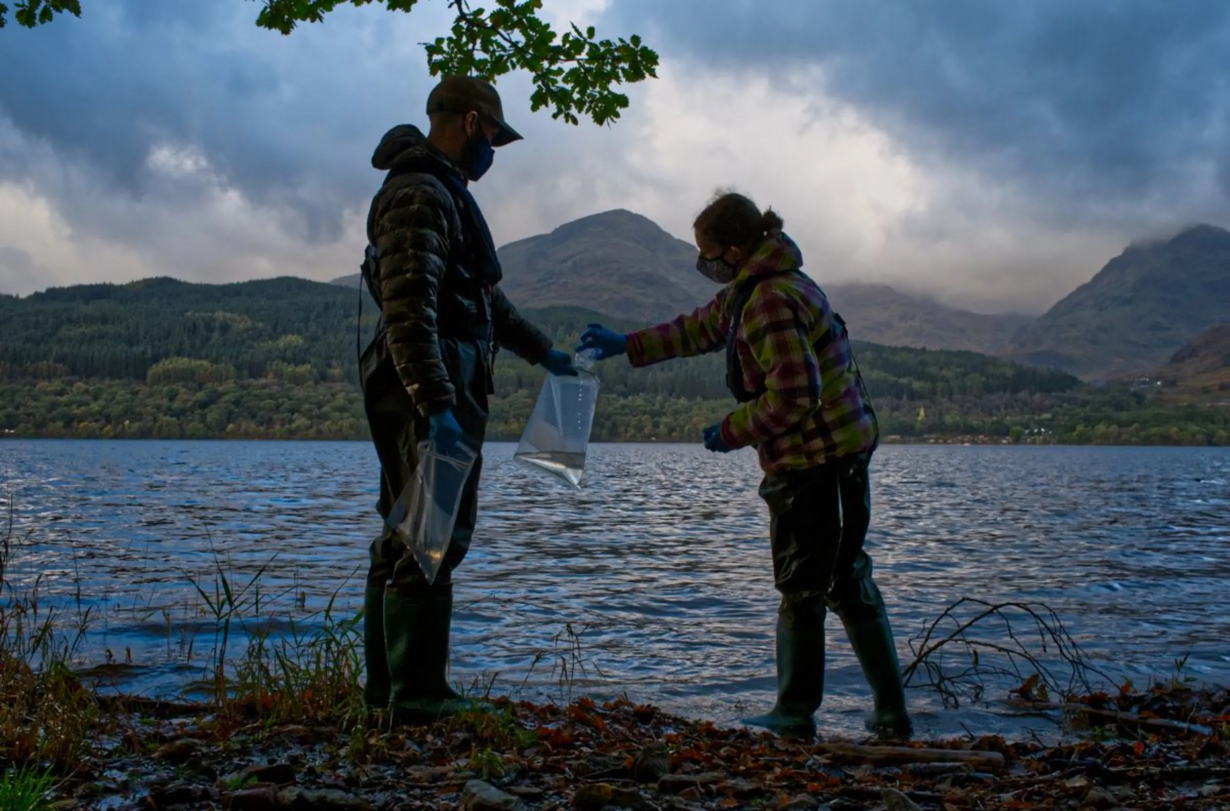 Scientists from monitoring company NatureMetrics collect water to then capture traces of DNA to identify local wildlife species, in The Trossachs National Park, Scotland, October 20, 2021