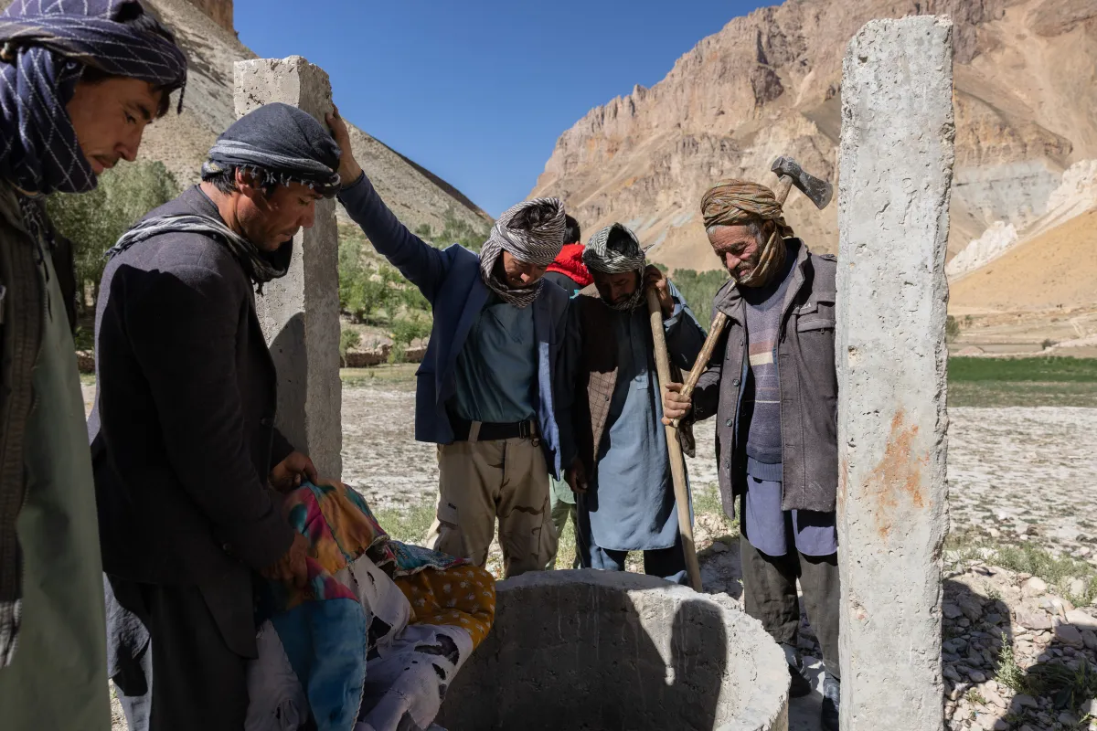 Villagers look down a well that has dried up in Bamyan, Afghanistan