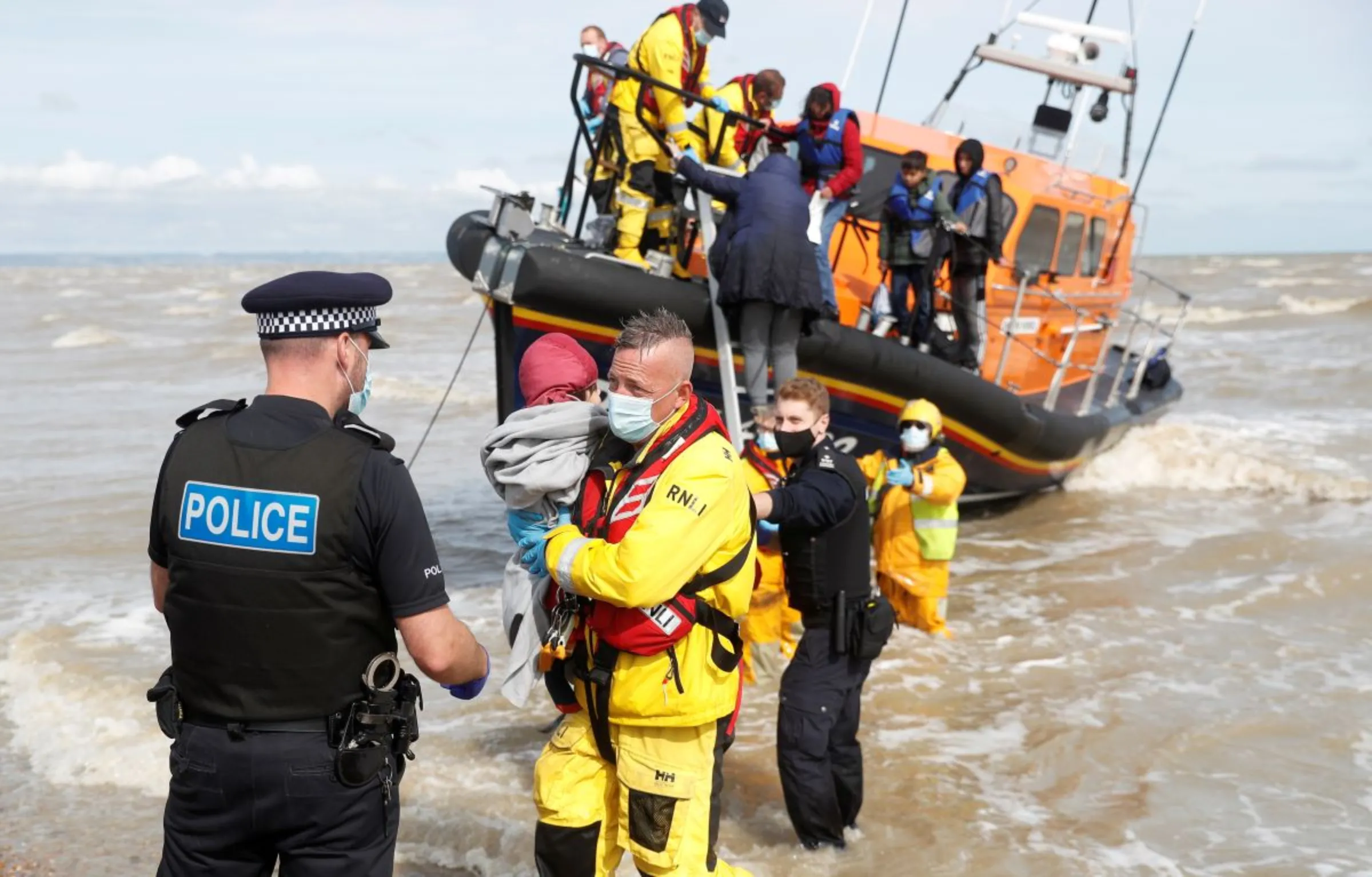 A RNLI boat, with migrants onboard, is met by Border Force Officers and Police at the harbour in Dungeness, Britain, September 13, 2021. REUTERS/Peter Nicholls