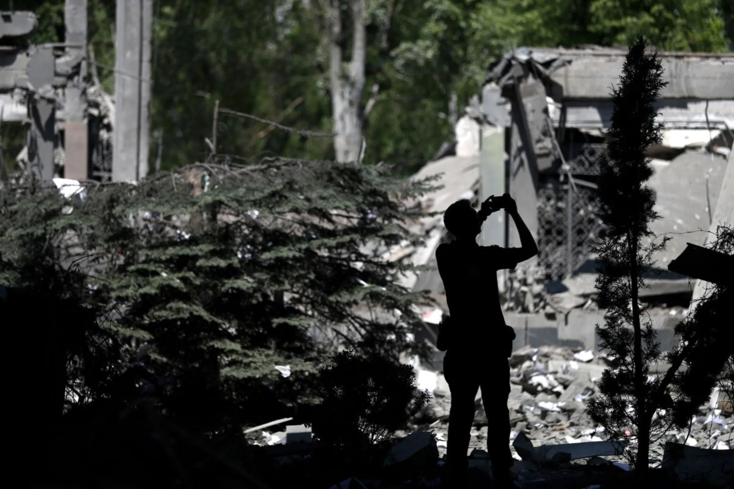 A prosecutor's office member uses a mobile phone inside a damaged school after a missile strike, amid Russia's attack on Ukraine, at a residential area in Kharkiv, Ukraine Jun 2, 2022. REUTERS/Ivan Alvarado