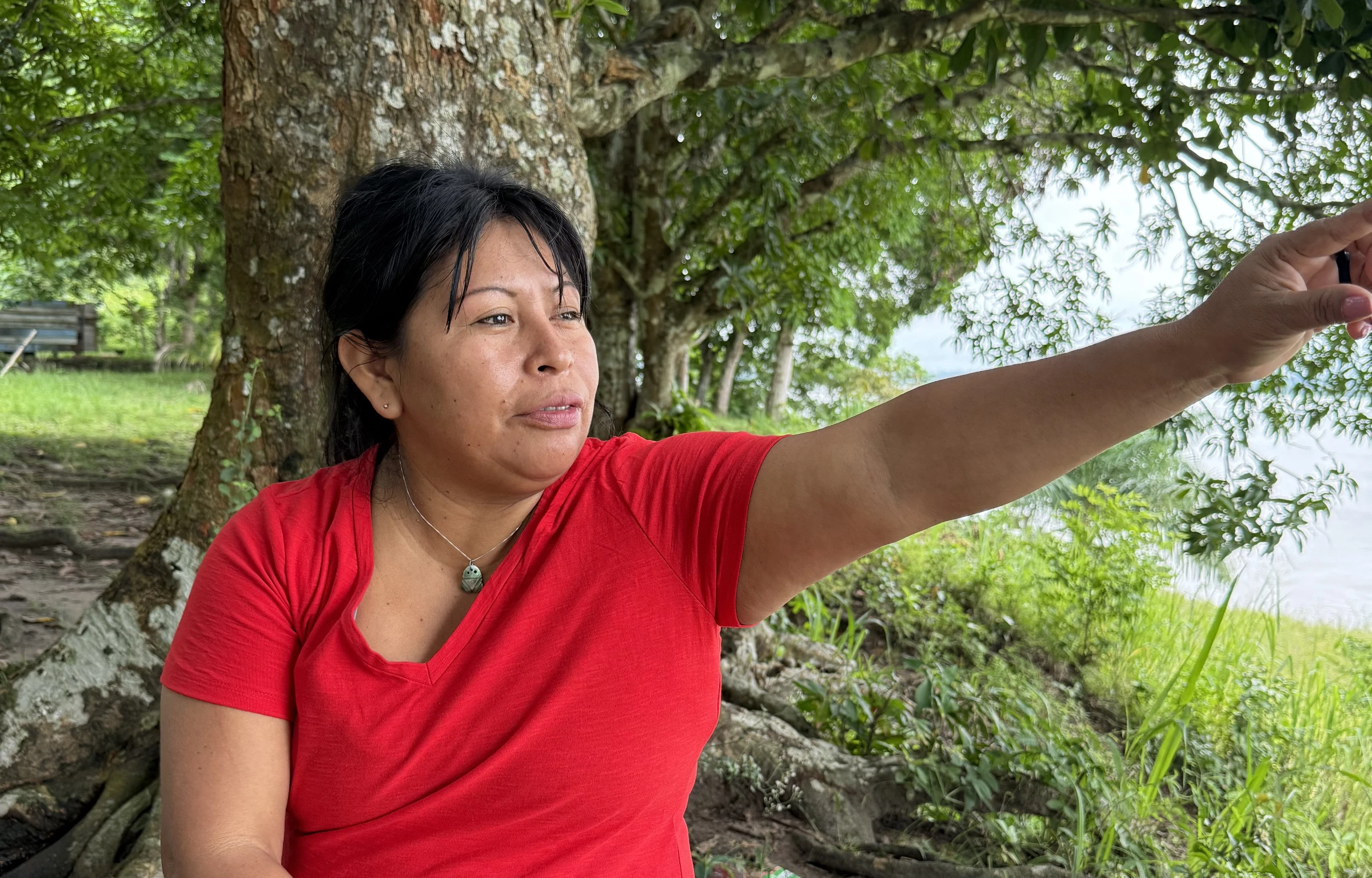 Alessandra Korap, 40, an Indigenous Munduruku leader points at the River Tapajós near her home in the Munduruku Indigenous Reserve, Brazil. She has faced multiple death threats for leading opposition against mining on Indigenous lands. Jan 11, 2025. Thomson Reuters Foundation/Dan Collyns