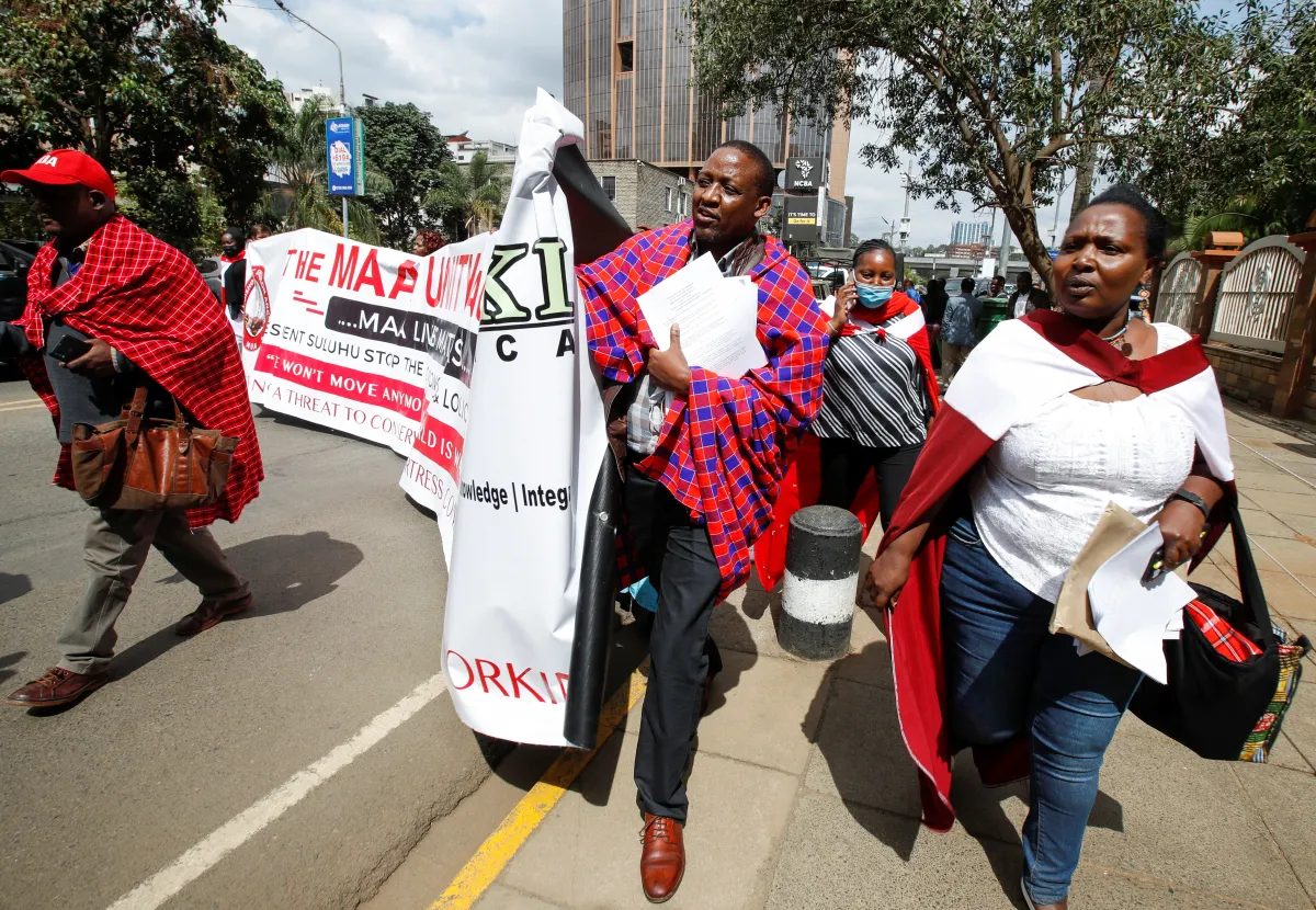 Members of the Maasai ethnic community in Kenya march during a protest against the eviction of their compatriots from Tanzania, holding a banner