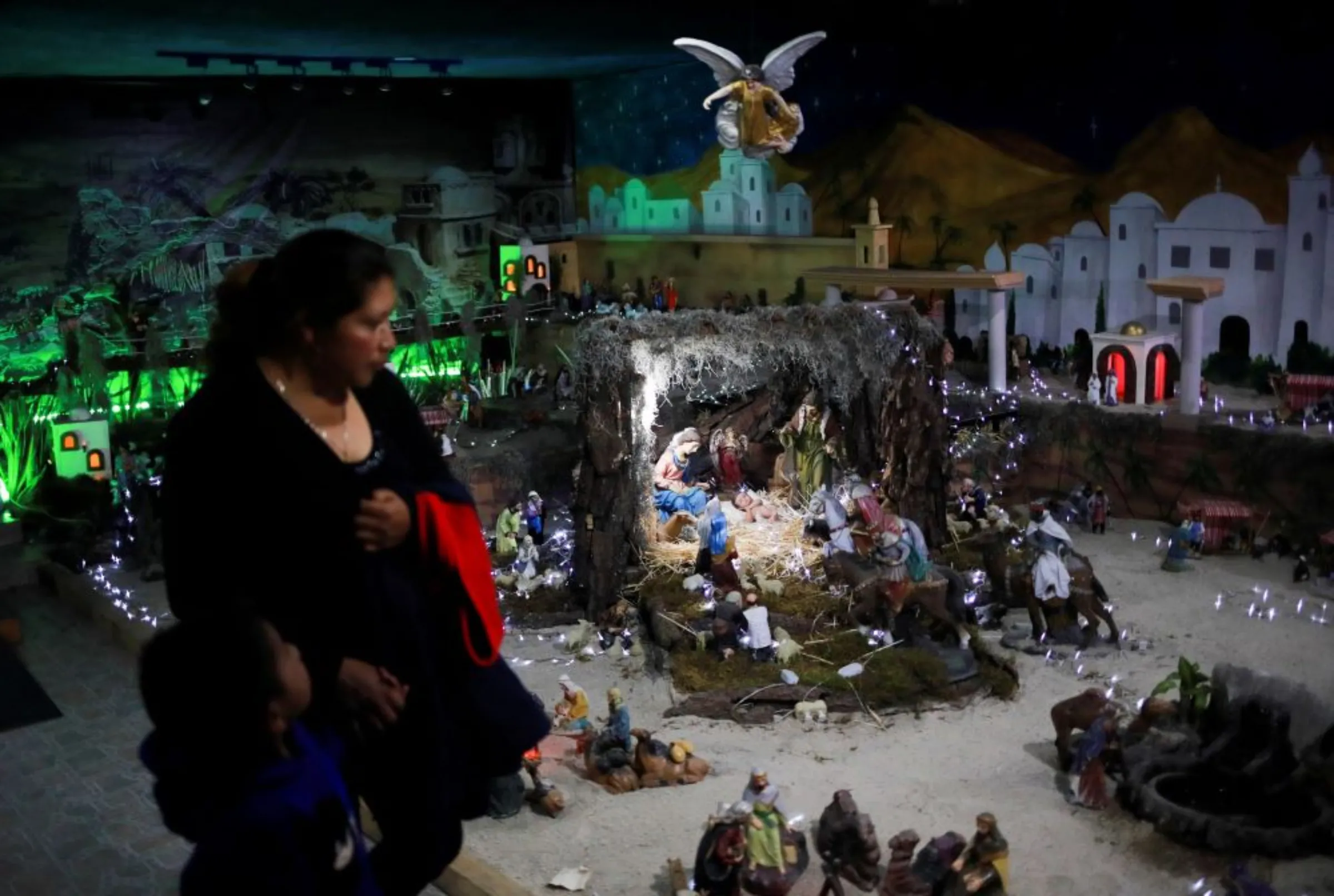 Visitors look at a giant set that represents the Nativity of Bethlehem, as part of the Mexican traditions for the Christmas holiday season in the house of the Ontiveros family, in Mexico City, Mexico, December 14, 2022. REUTERS/Henry Romero