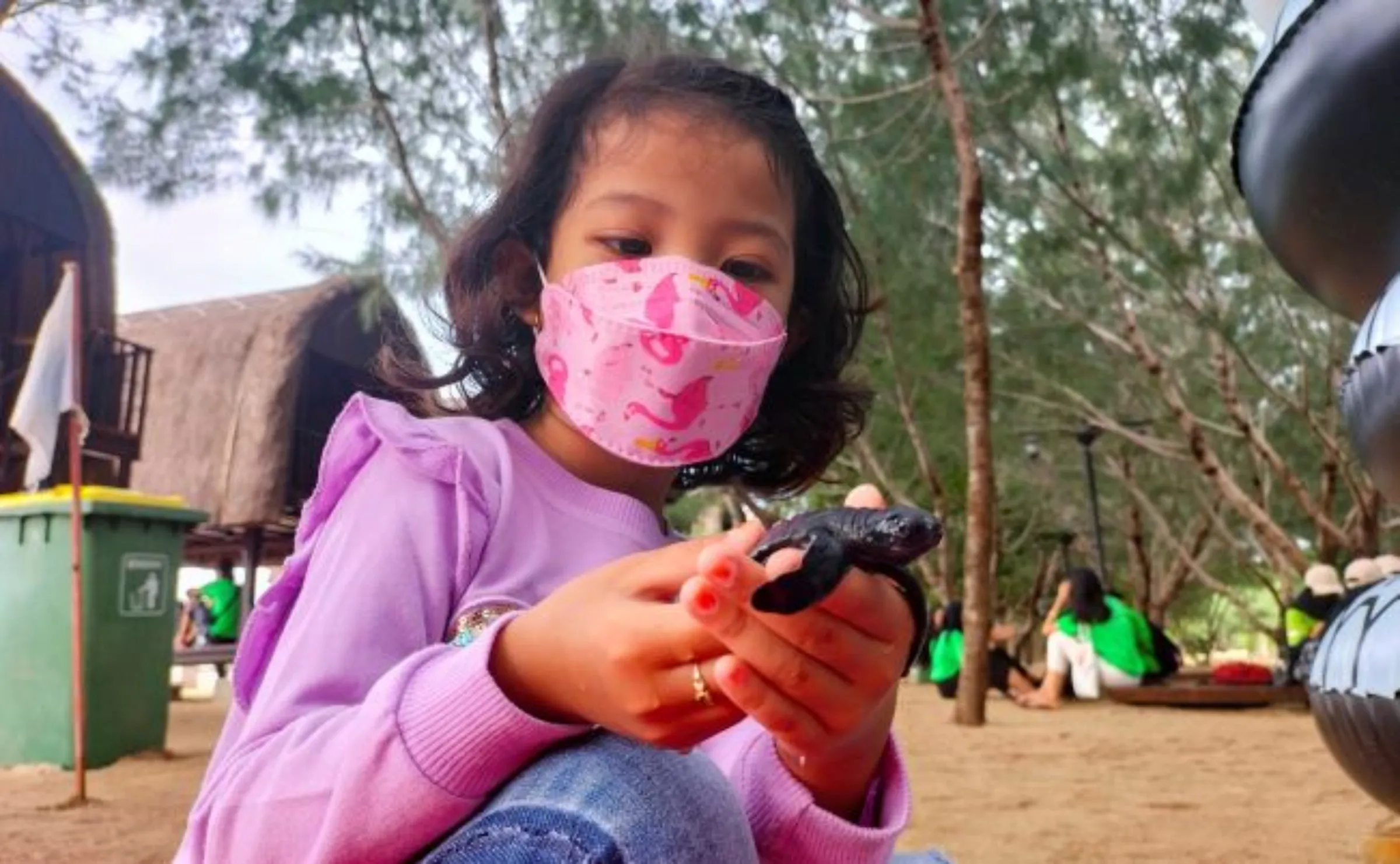 A girl holds a baby Olive Ridley sea turtle (Lepidochelys olivacea), that was rescued from predators by the local conservation community and will be released to the sea, in Sanur, Bali, Indonesia, January 20, 2022. REUTERS/Sultan Anshori