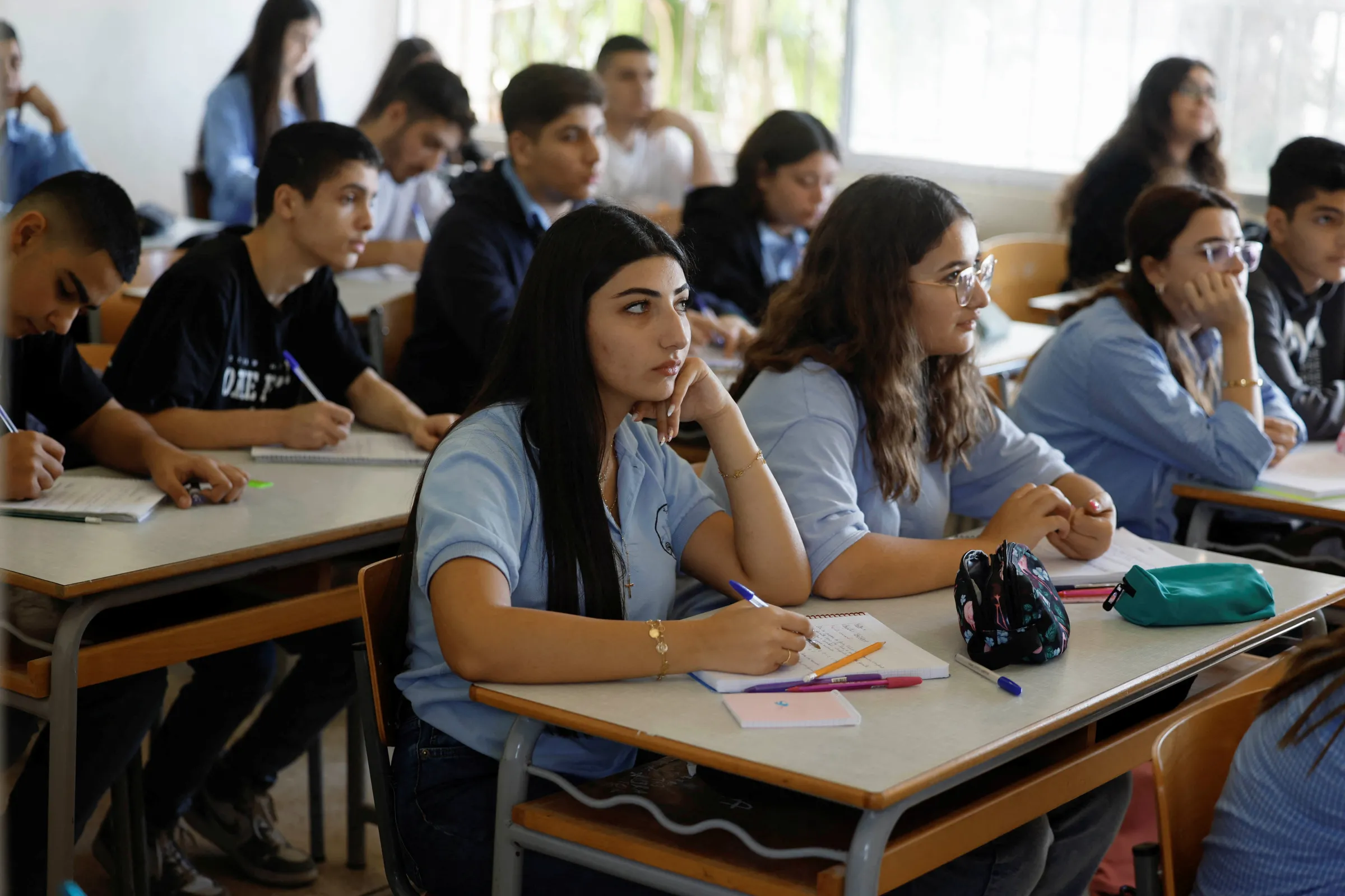 Lebanese students attend lessons at a public school, which is hosting displaced people in one of its buildings, in Amchit, Lebanon, November 11, 2024. REUTERS/Thaier Al-Sudani