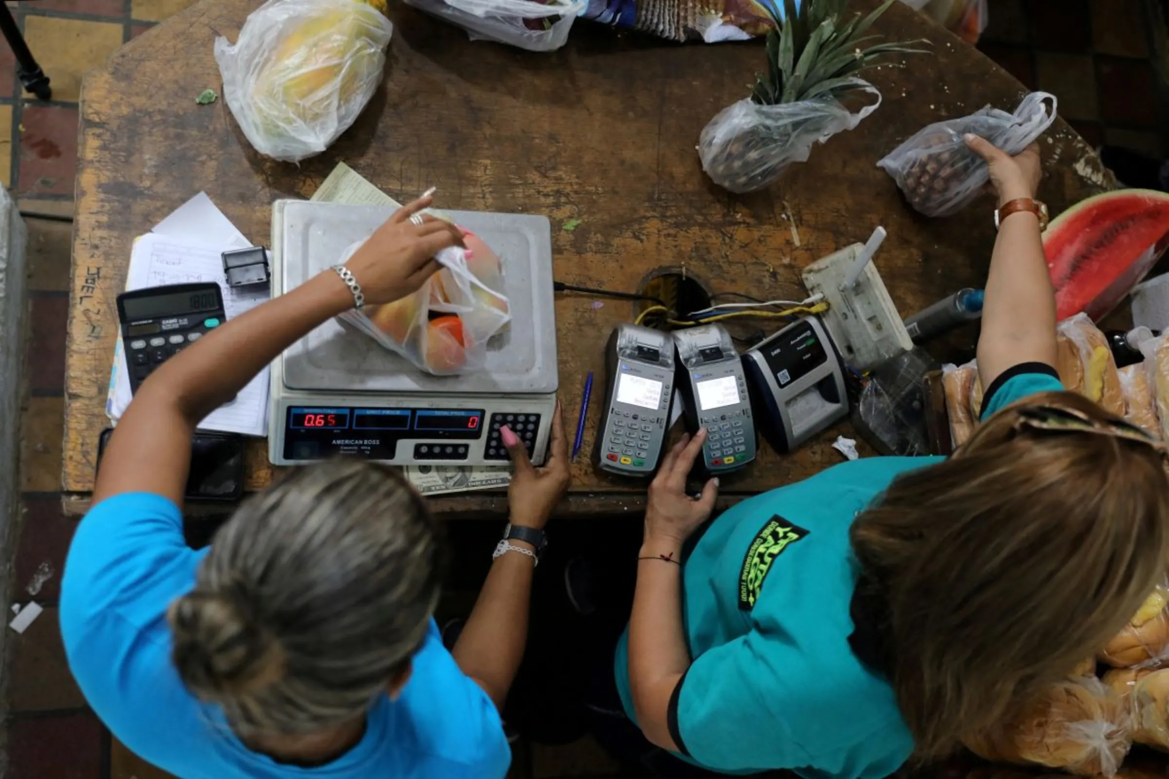 Workers weigh goods in an open-air fruit and vegetable market in Caracas, Venezuela December 22, 2020