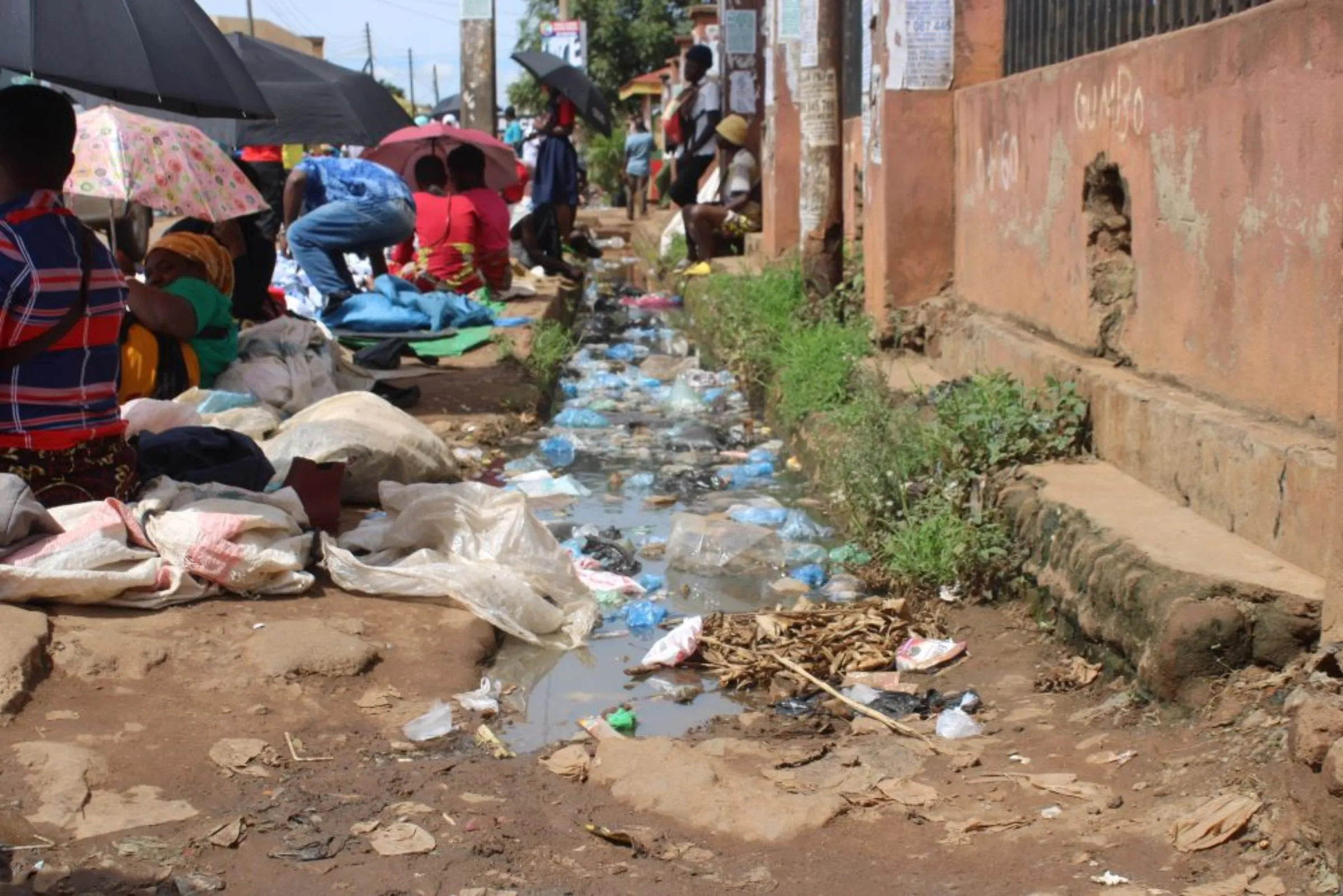 Vendors selling clothes and other merchandise in the city of Lilongwe, Malawi. Behind them is polluted water. Poor drainage facilities is one of the problems in the cities. January 11, 2023