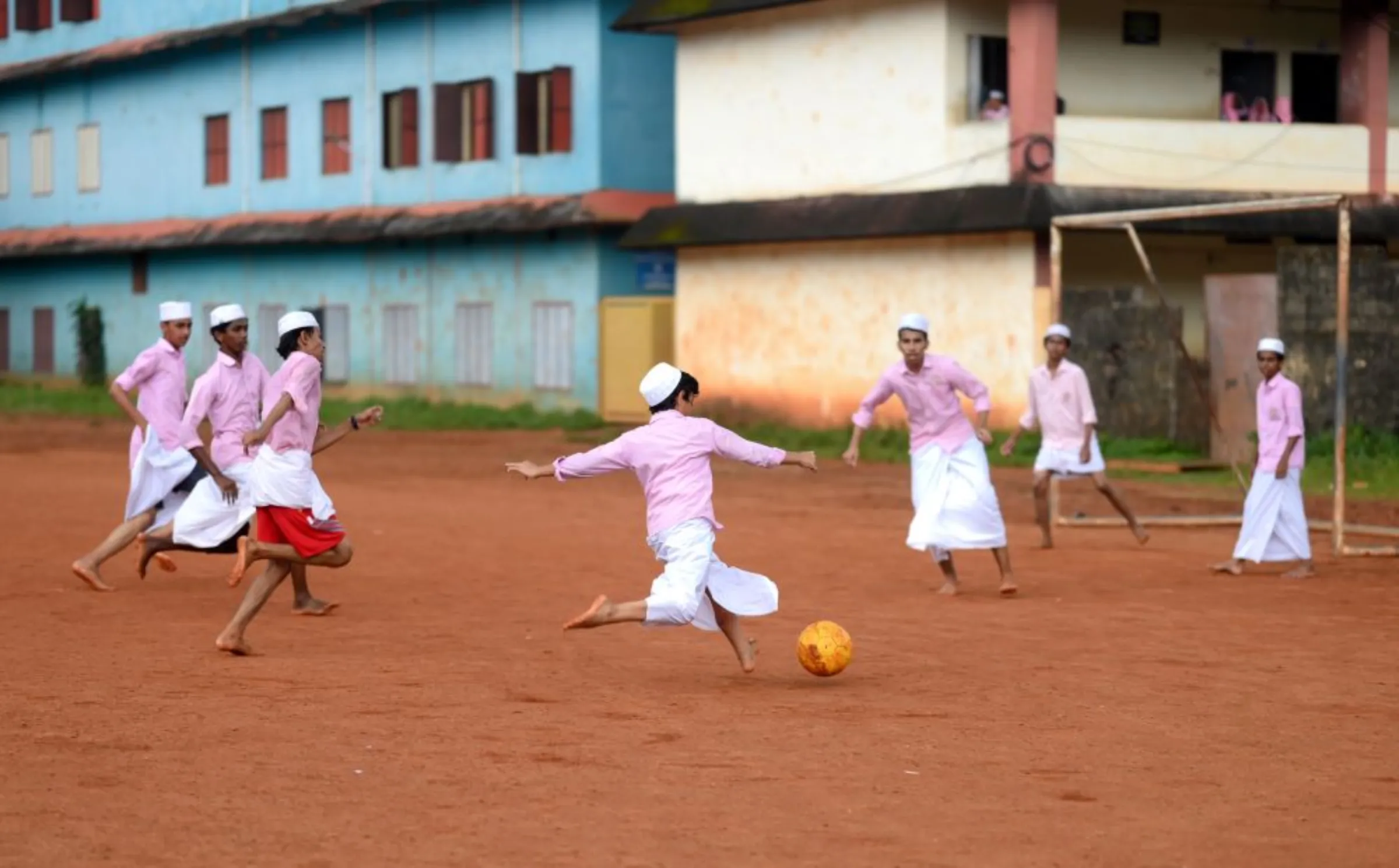 Students playing football at the Pookkottur government higher secondary school ground in Malappuram, India, August 29, 2022. Thomson Reuters Foundation/Gokul