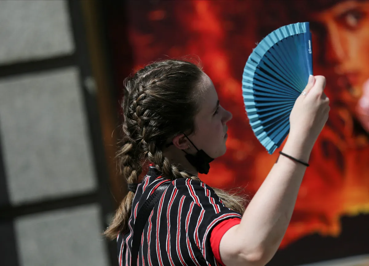 A woman uses a fan as she walks, during the second heatwave of the year, in Madrid, Spain, July 20, 2022