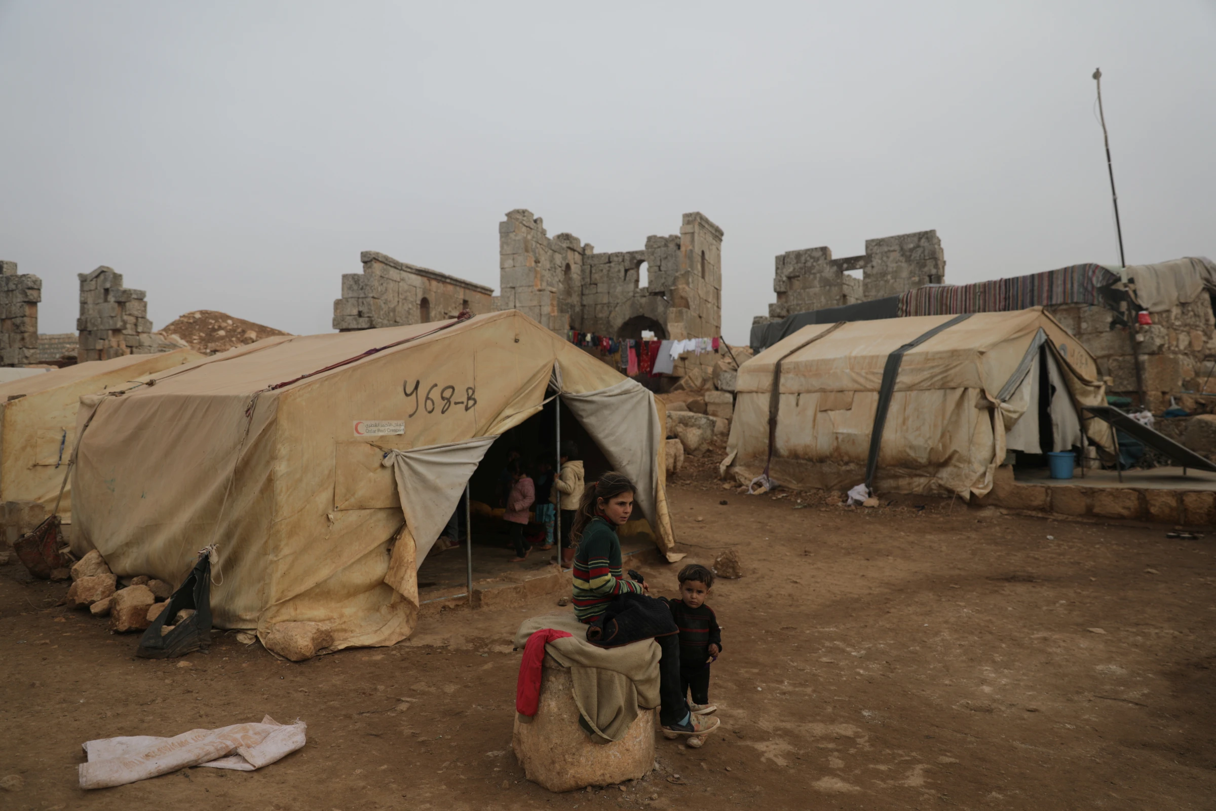 A girl sits in front of her family's tent in Babisqa, in the northern countryside of Idlib, Syria, November 2021. REUTERS/Khalil Ashawi