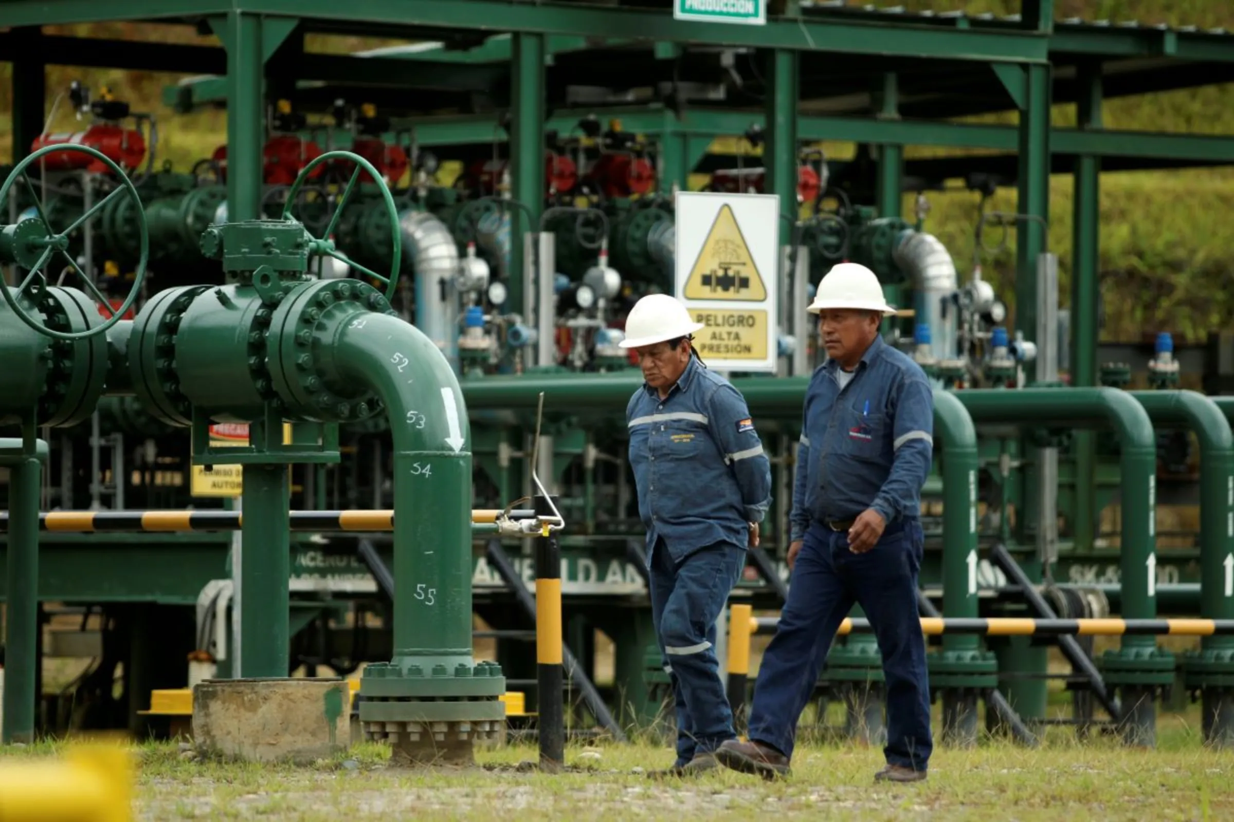 Oil field technicians walk at an oil field of Ecuador's state oil company Petroamazonas, in Yasuni, Ecuador October 20, 2017