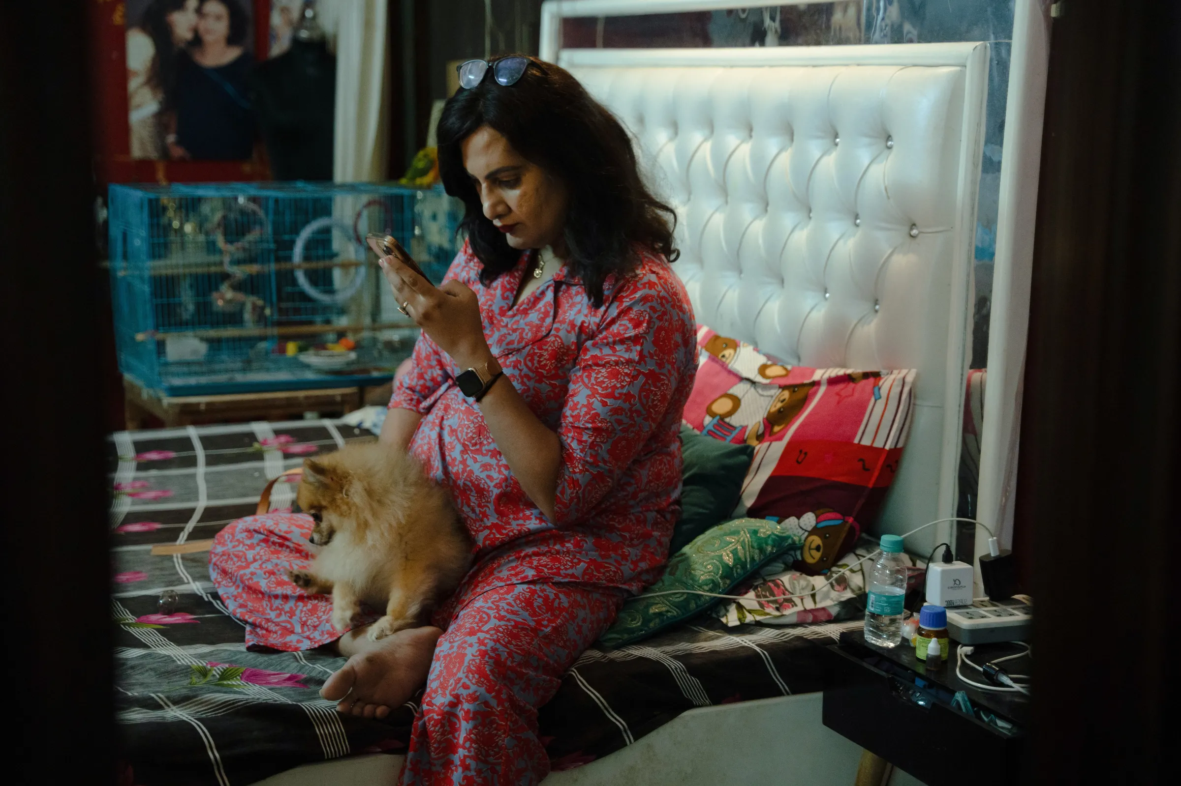 Naaz Joshi, a 47-year-old trans woman, scrolls through her phone at home in Dehli, India, August 26, 2024. Thomson Reuters Foundation/Mehran Firdous