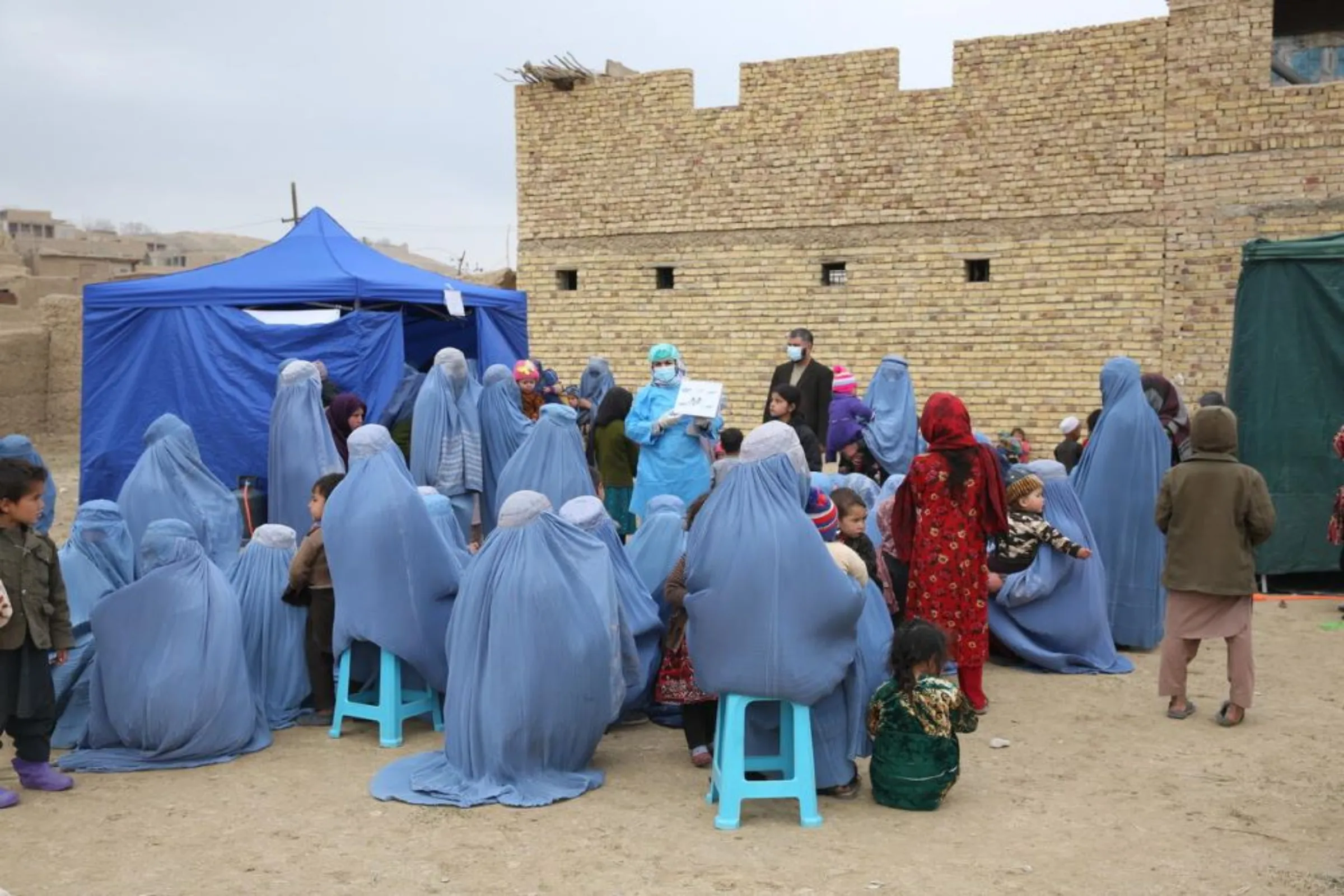 Women and children wait outside a mobile health clinic in Faryab Province, Afghanistan, February 21, 2022