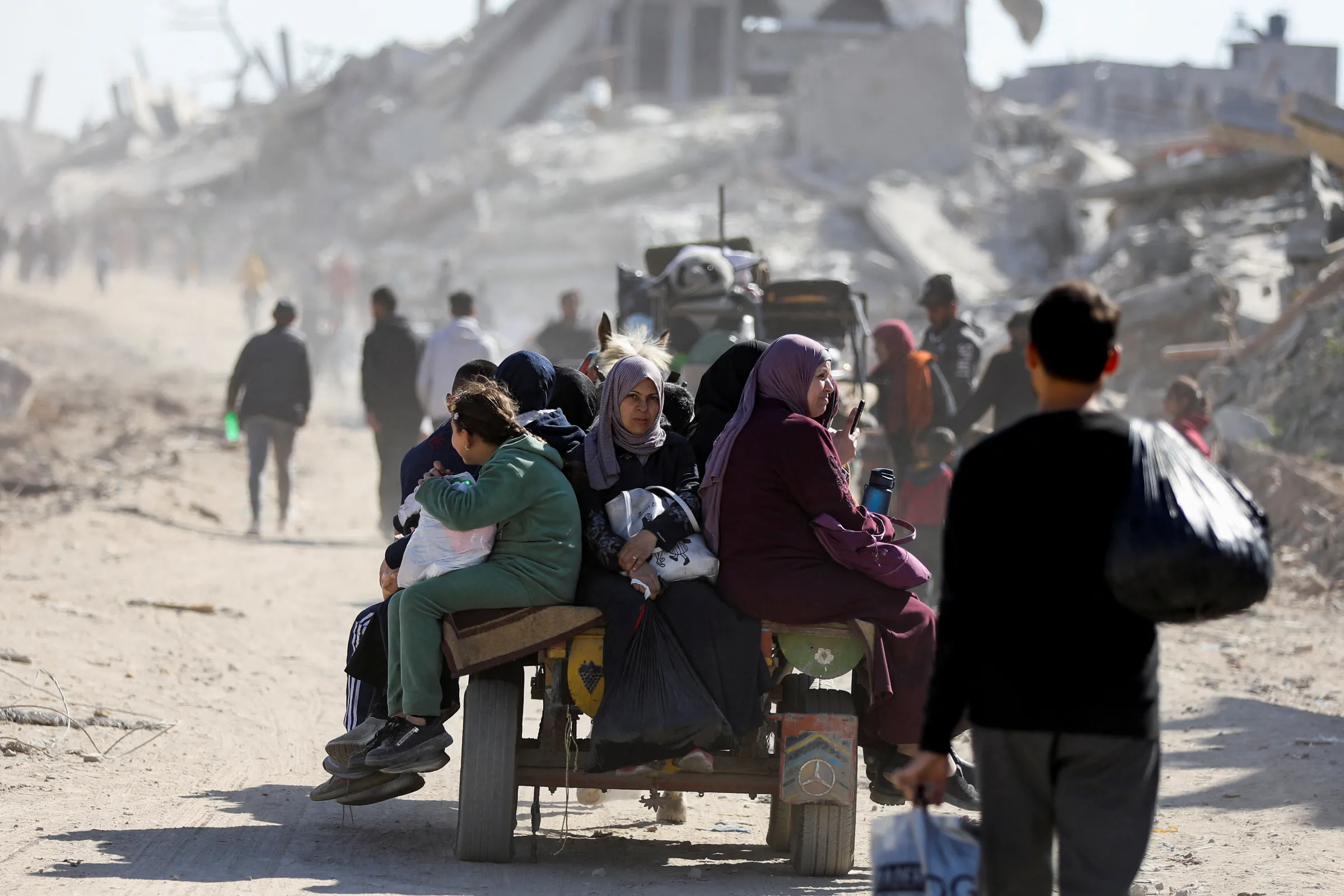 Palestinians make their way past the rubble of destroyed houses and buildings, following a ceasefire between Israel and Hamas, in Jabalia in the northern Gaza Strip, January 21, 2025. REUTERS/Dawoud Abu Alkas