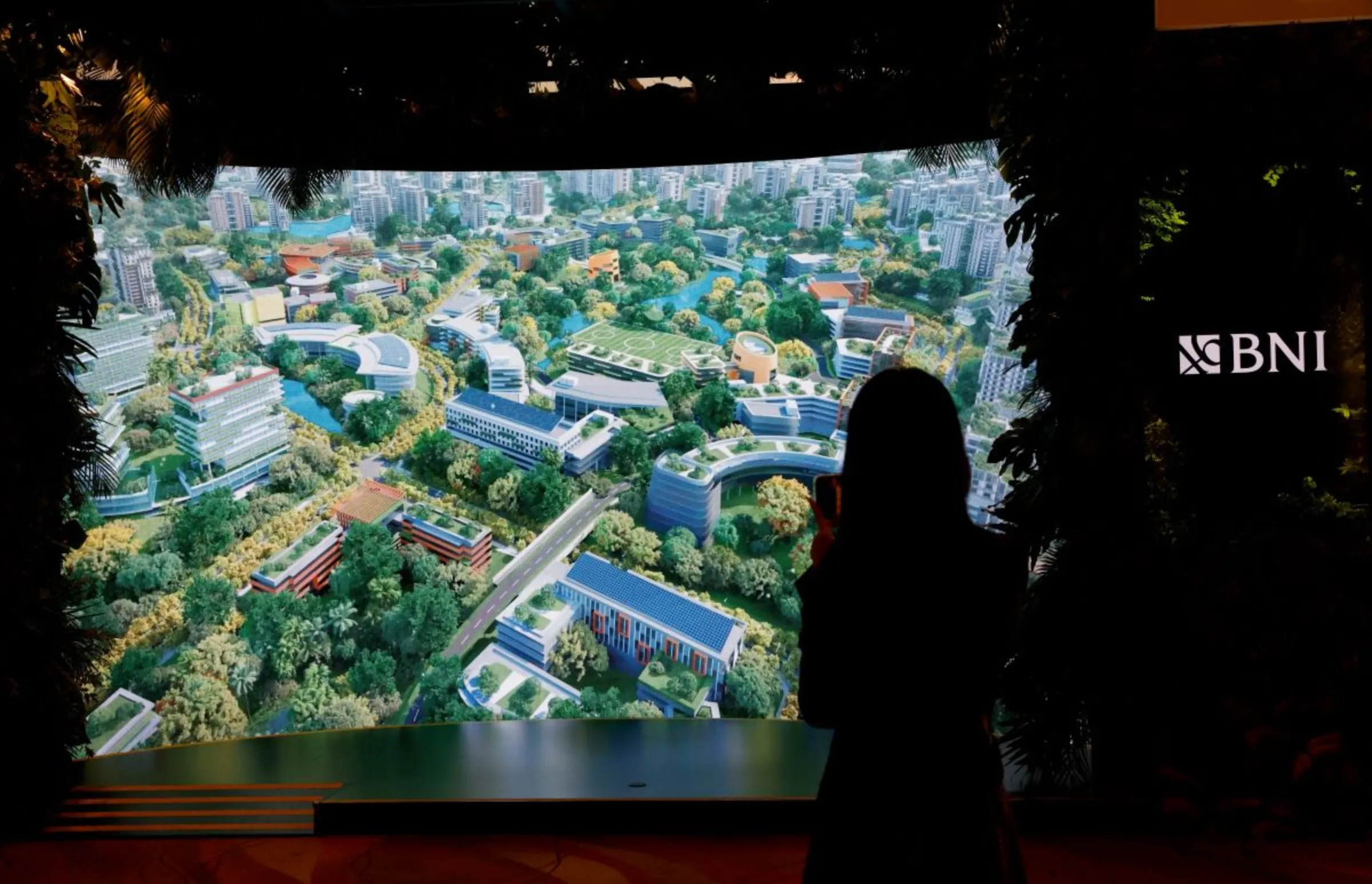 An attendee films a video presentation of Indonesia's new planned capital Nusantara, at Ecosperity Week in Singapore June 7, 2023. REUTERS/Edgar Su