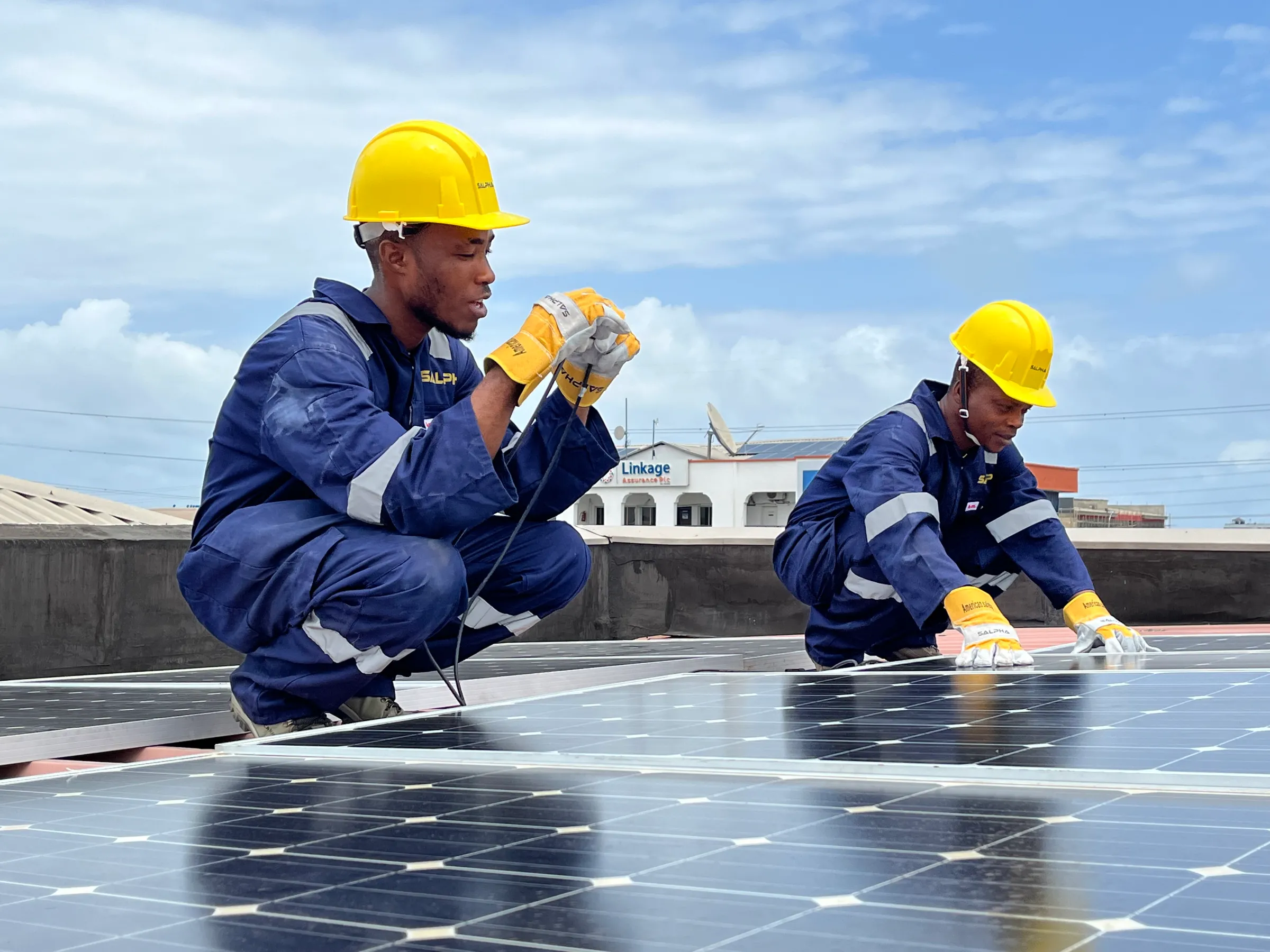 Solar engineers on the roof of a home in Lagos, Nigeria, in 2024. Emeka Iko/Ashden Climate Solutions/Handout via Thomson Reuters Foundation.
