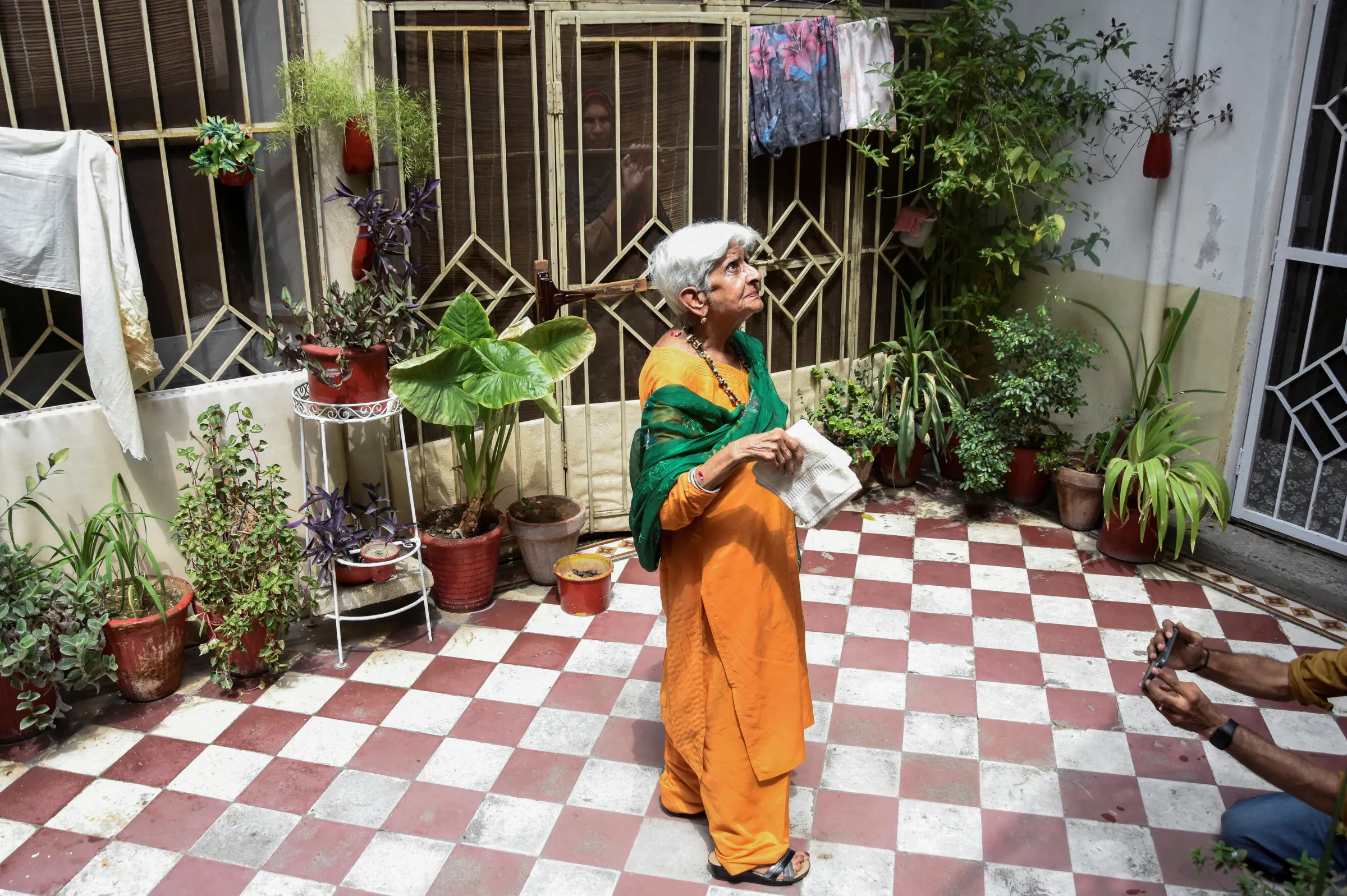 Reena Varma, 90-year-old Indian citizen born in Pakistan, stands at a neighbour's house next to her ancestral home