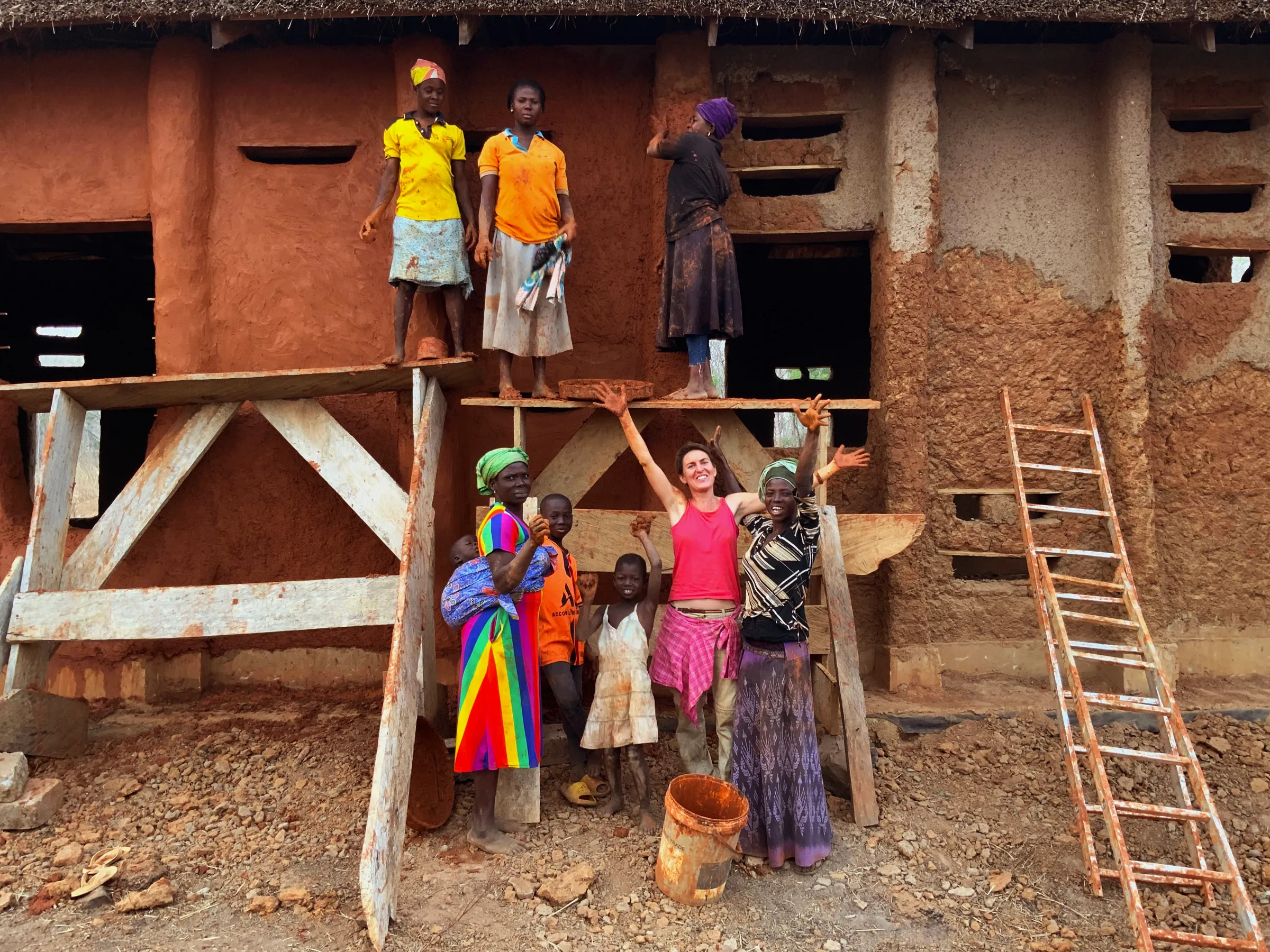 Architect Anna Heringer stands with villagers at the construction site for a school in northeast Ghana in 2022. Photo by Don Bosco. Studio Anna Heringer/Handout via Thomson Reuters Foundation
