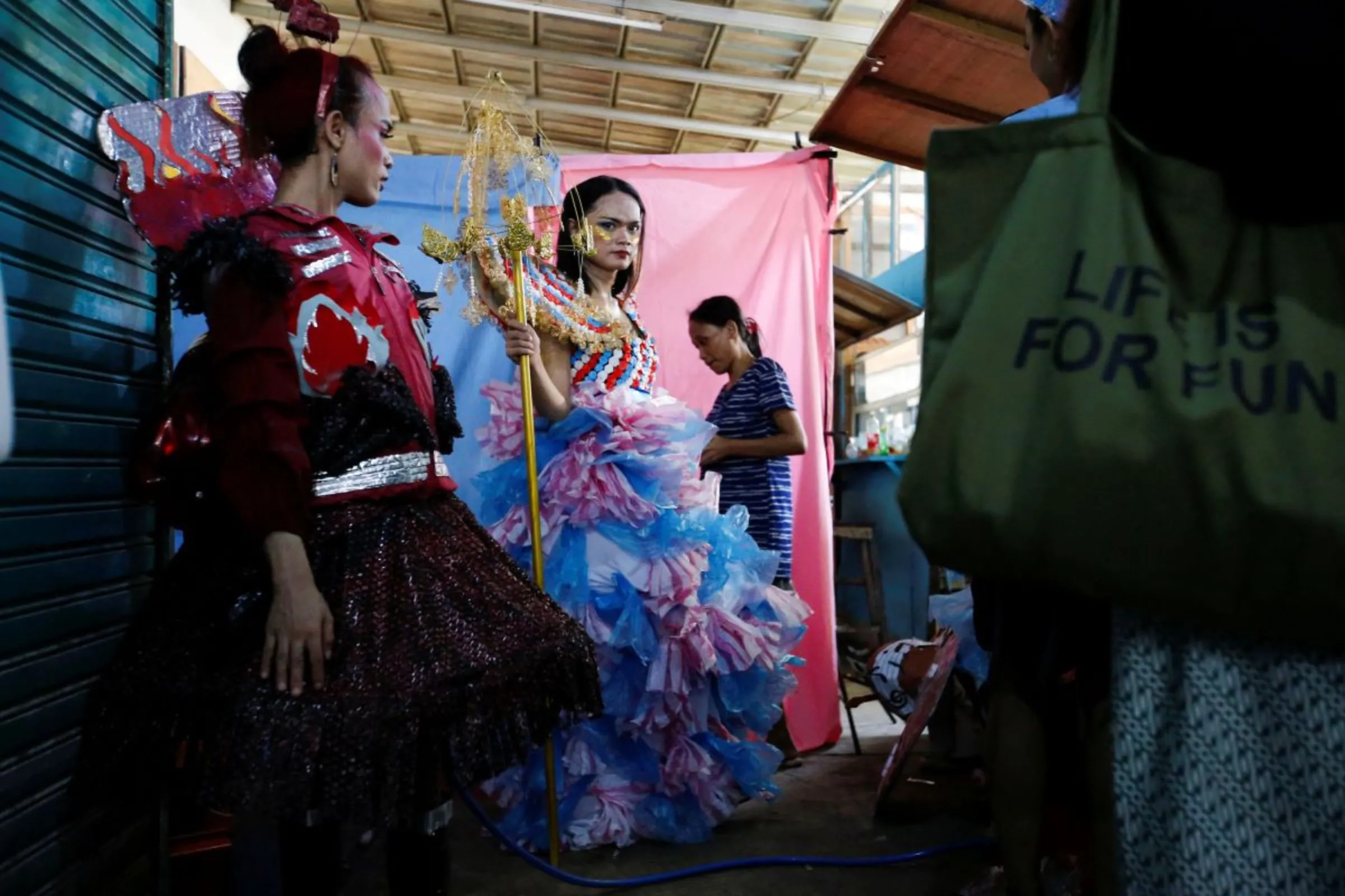 Trans women wearing recycled material dresses to bring awareness to LGBT rights and environmental protection stand before a Trans Super Heroes fashion show at a traditional market in Jakarta, Indonesia, December 17, 2023. REUTERS/Ajeng Dinar Ulfiana