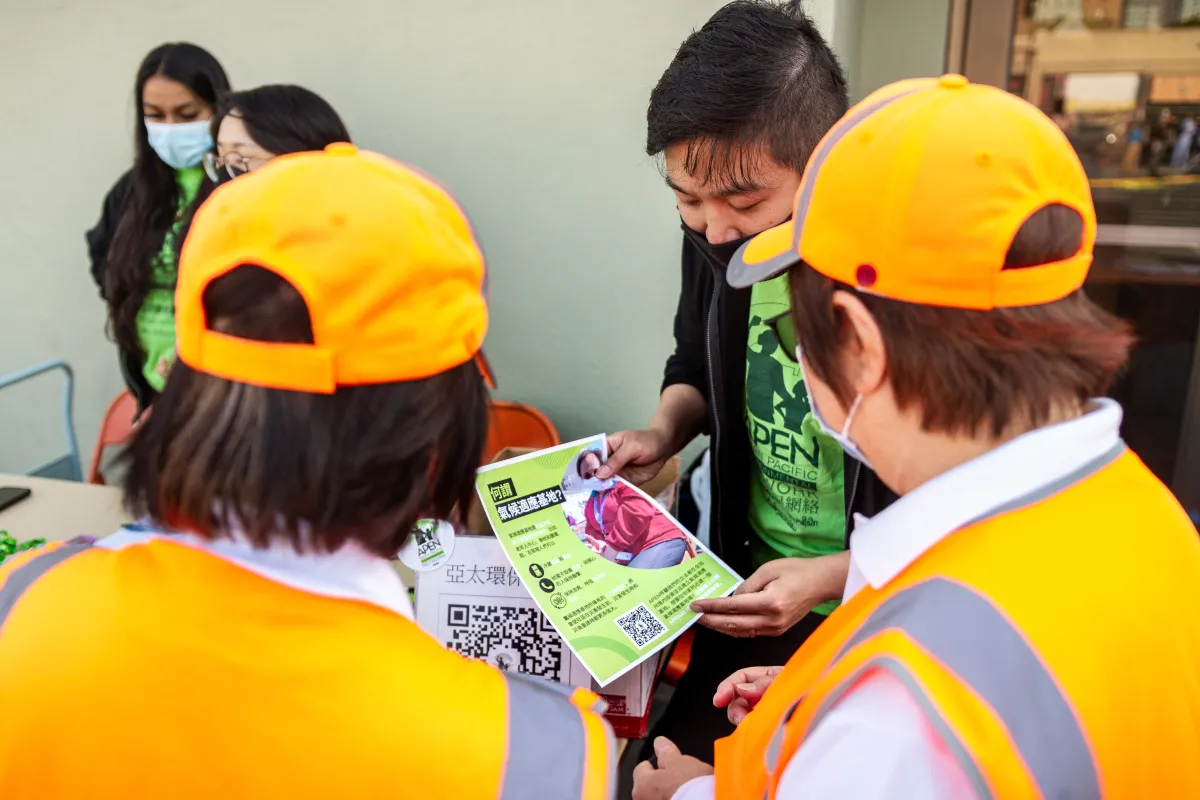 People stand discussing a leaflet