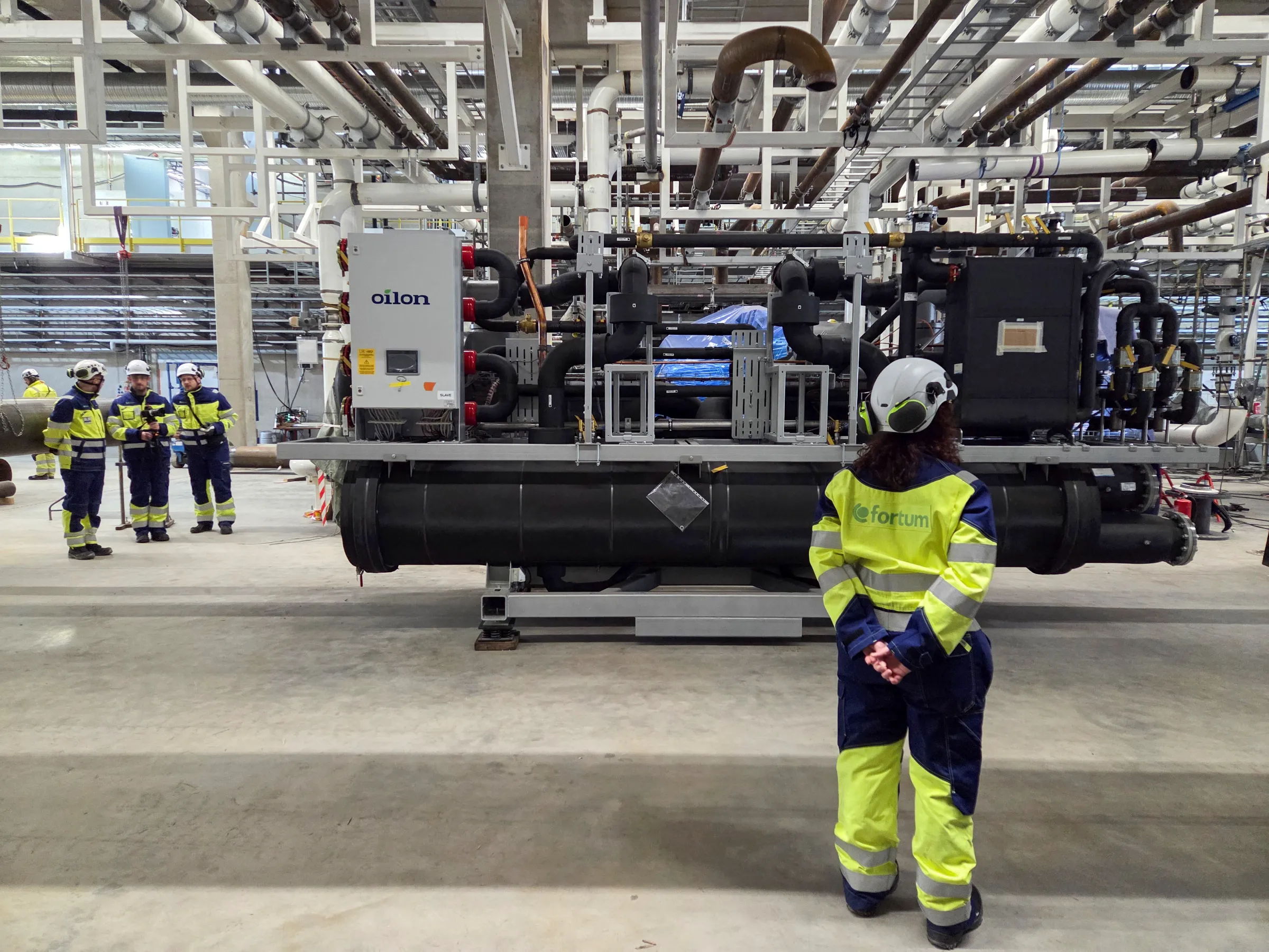 Visitors look at a heat pump that awaits assembling inside utility Fortum’s heat pump room that is under construction next to Microsoft’s new data centre site in Kirkkonummi, Finland March 7, 2025. REUTERS/Anne Kauranen