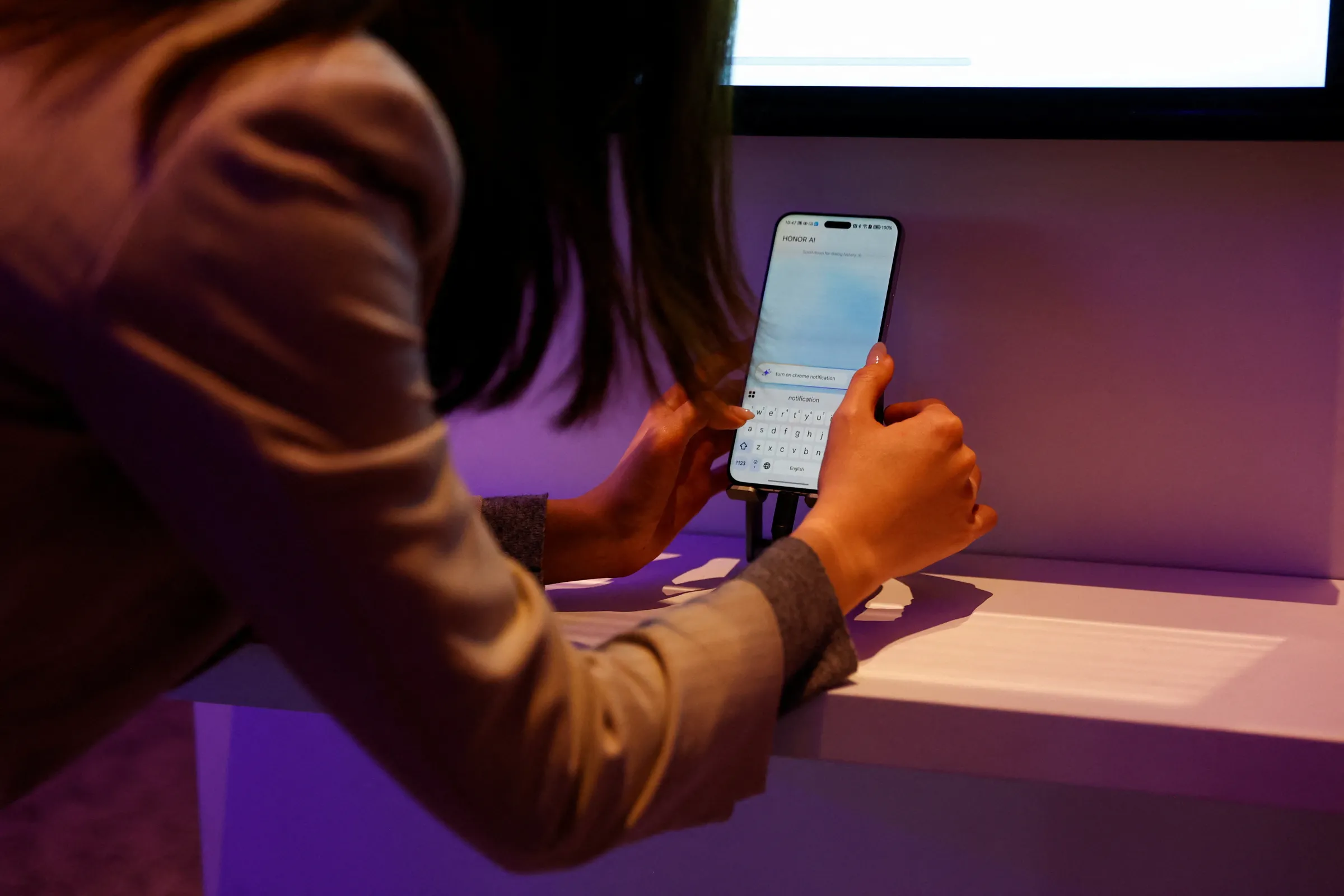 A woman tries to make a booking to a restaurant with the new AI feature in the Magic 7 Pro smartphone from Honor, in Barcelona, Spain March 2, 2025. REUTERS/ Bruna Casas