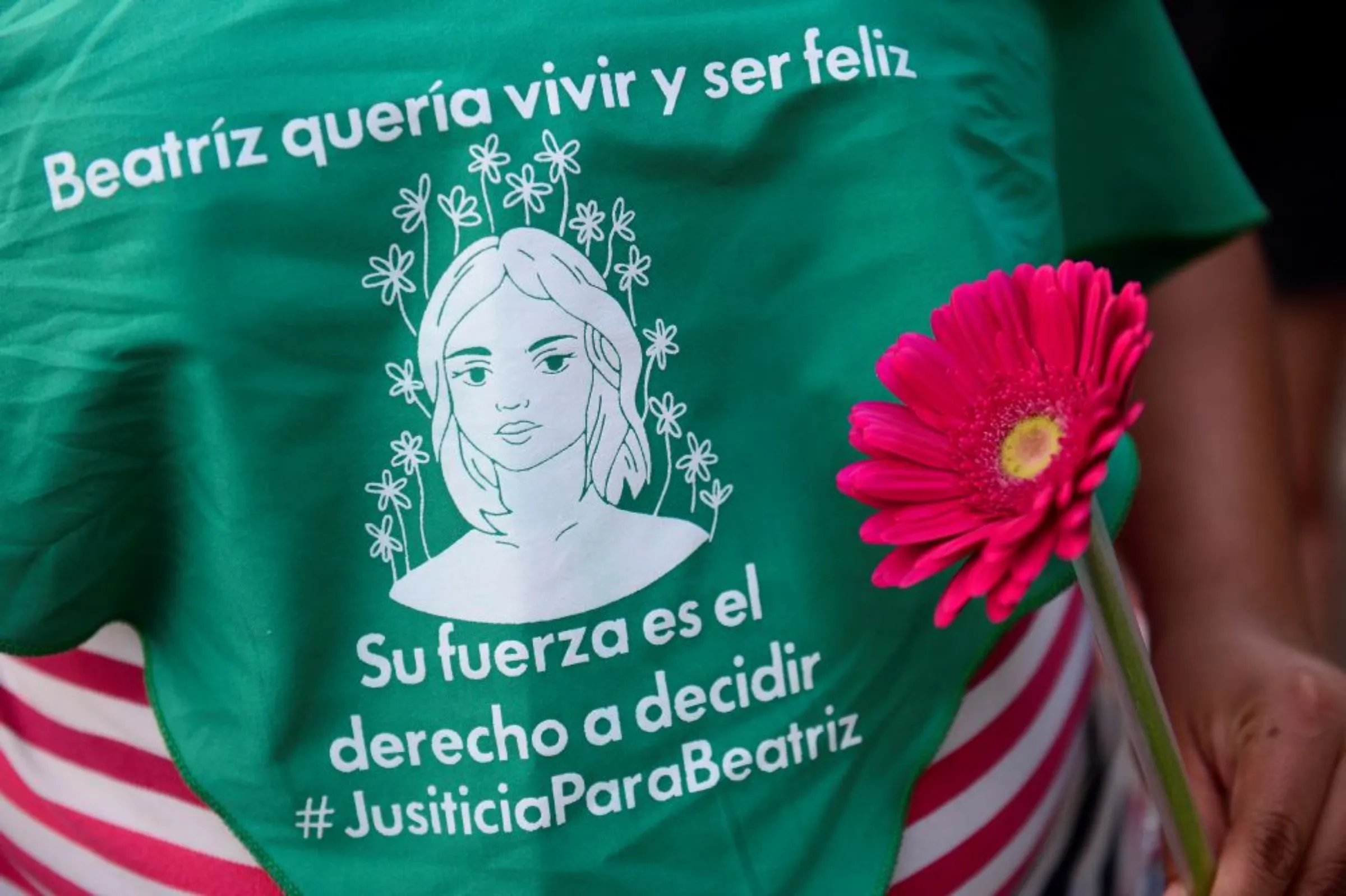 A woman holds a flower near a green handkerchief in memory of Beatriz, a woman who died after El Salvador's supreme court denied her a medical abortion, during a protest in support of abortion rights in San Salvador, El Salvador, October 18, 2022