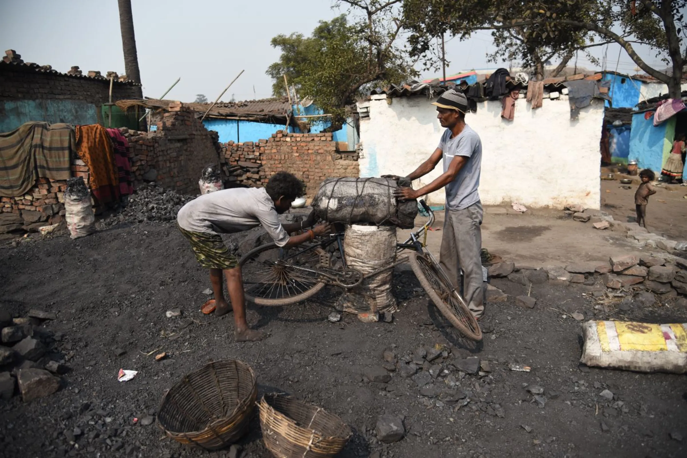 A man ties sacks of stolen coal to a bicycle in Jharia, India, November 10, 2022. Thomson Reuters Foundation/Tanmoy Bhaduri