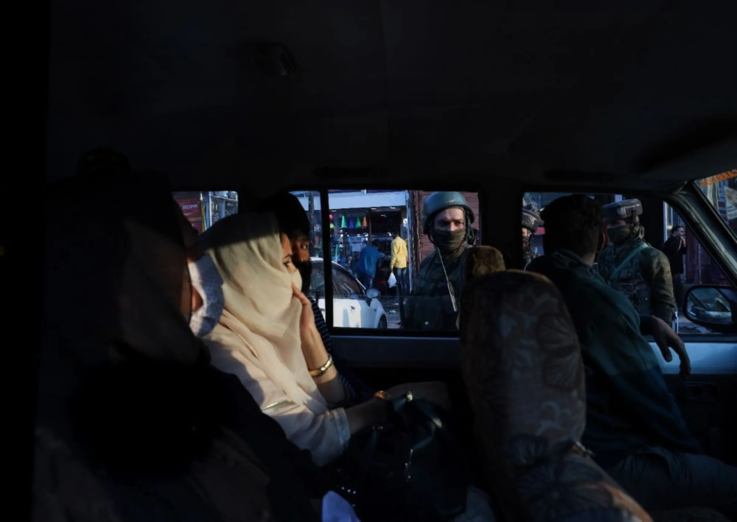 Security forces check the identification documents of passengers in a taxi in the Kashmiri city of Srinagar, India. ‎October ‎22, ‎2021