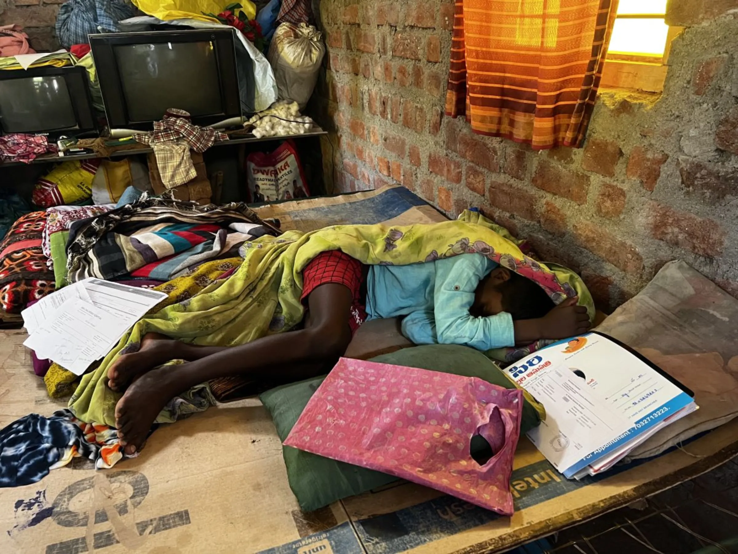 A young boy lies ill in bed after swimming in a stream that residents say was polluted by a new ethanol plant near Chittanur village in Telangana state, India, October 17, 2023