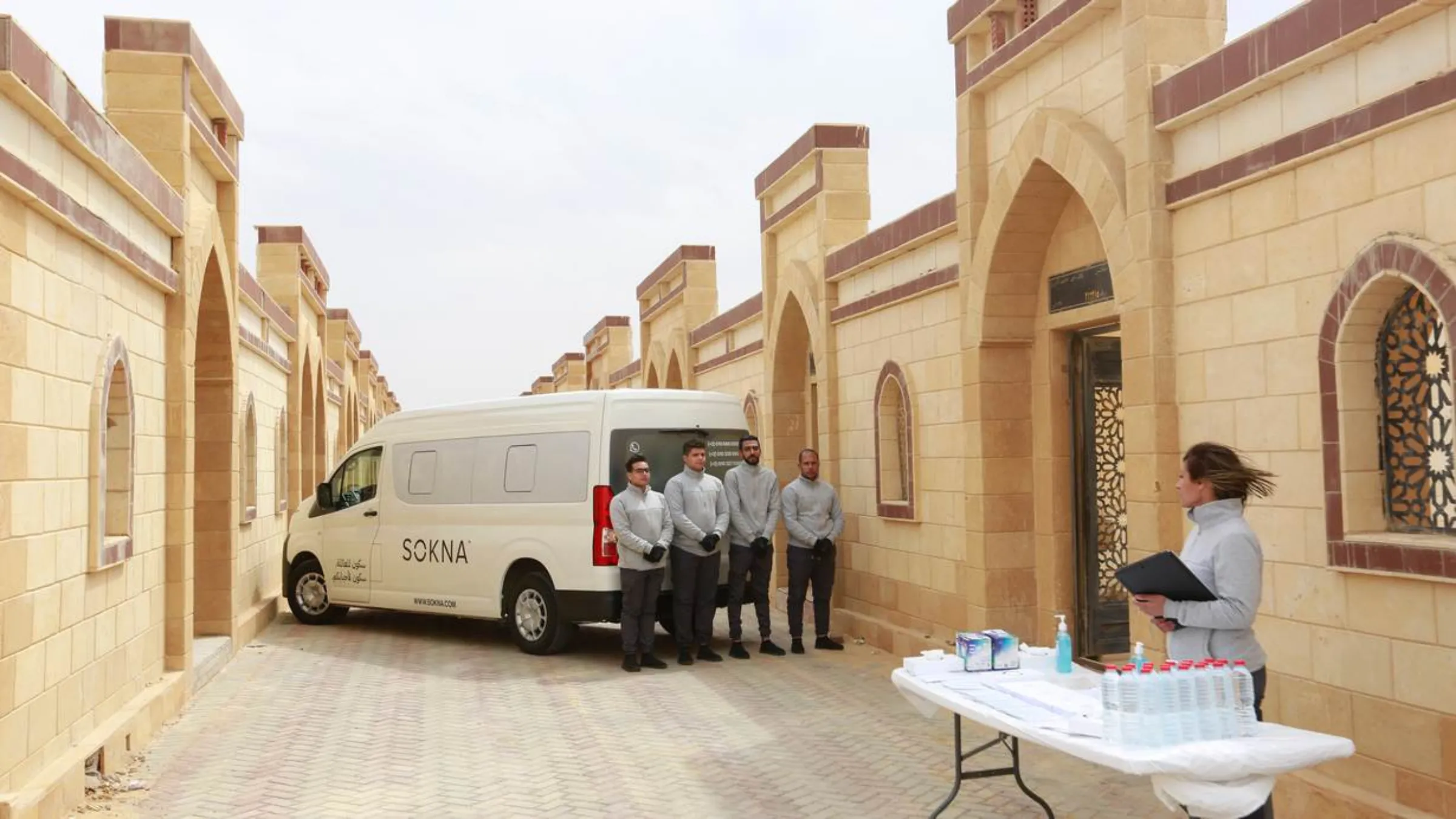 SOKNA team standing outside a tomb where they are waiting to welcome guests to a a funeral service in Cairo Egypt. May 10, 2022. Thomson Reuters Foundation/SOKNA