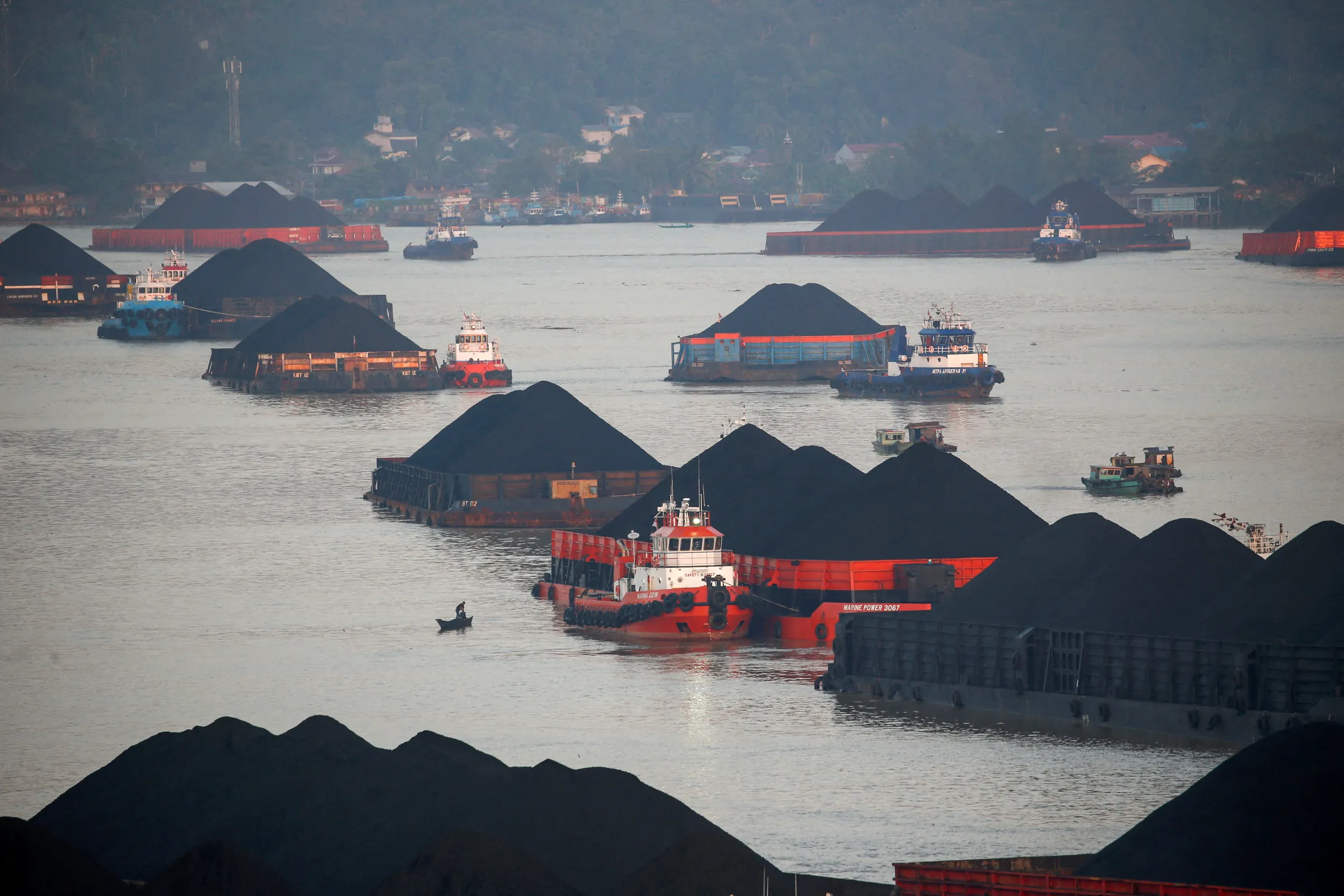 Coal barges are pictured as they queue to be pulled along Mahakam river in Samarinda, East Kalimantan province, Indonesia, August 31, 2019. REUTERS/Willy Kurniawan