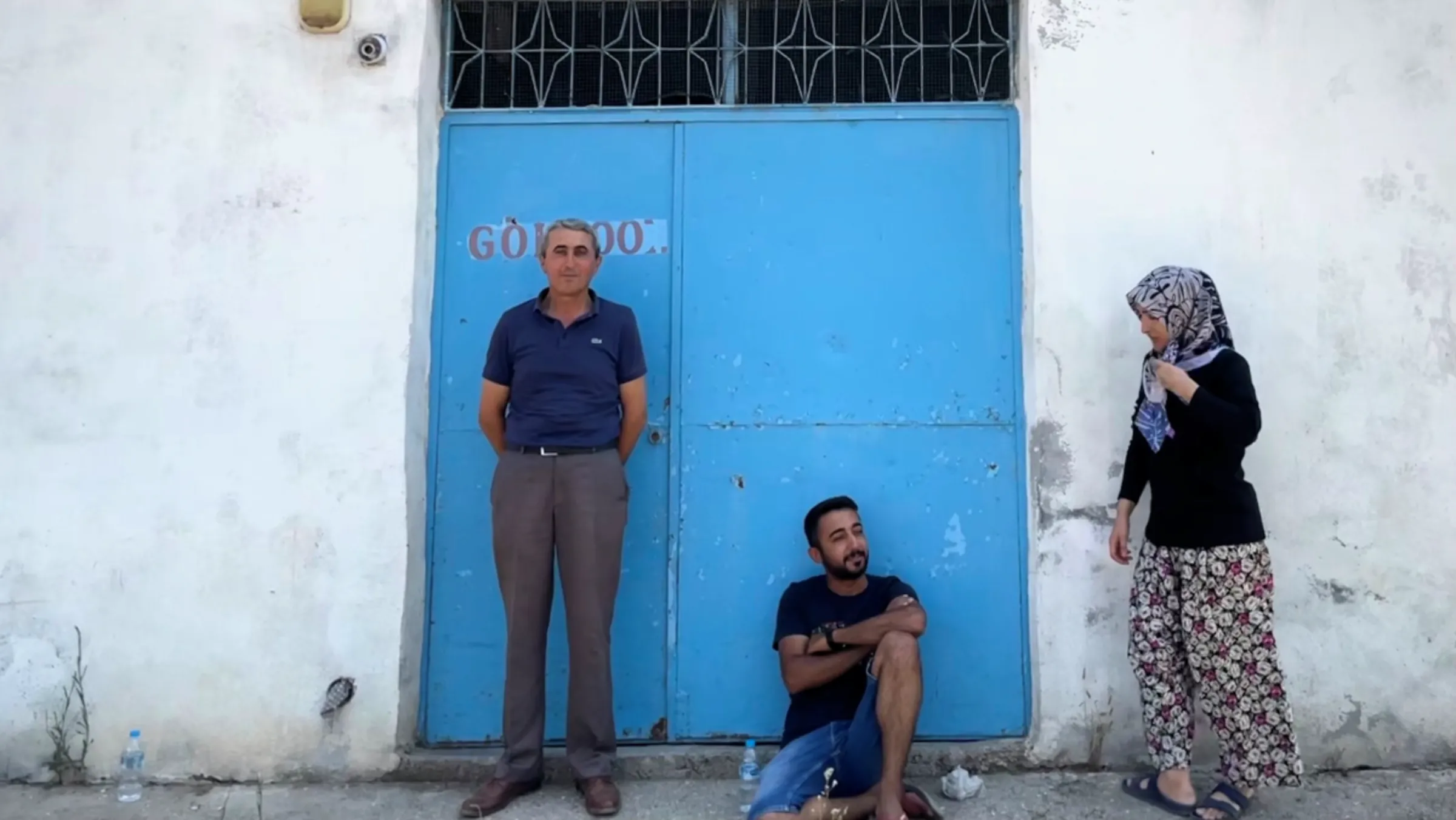 Former fisherman Mehmet Erefe, stands with his cousin Ali Erefe and neighbour Nimet Sezen outside the abandoned fishermen’s cooperative building on the edge of Lake Marmara, Manisa, Turkey. July 13, 2023. Thomson Reuters Foundation/Beatrice Tridimas