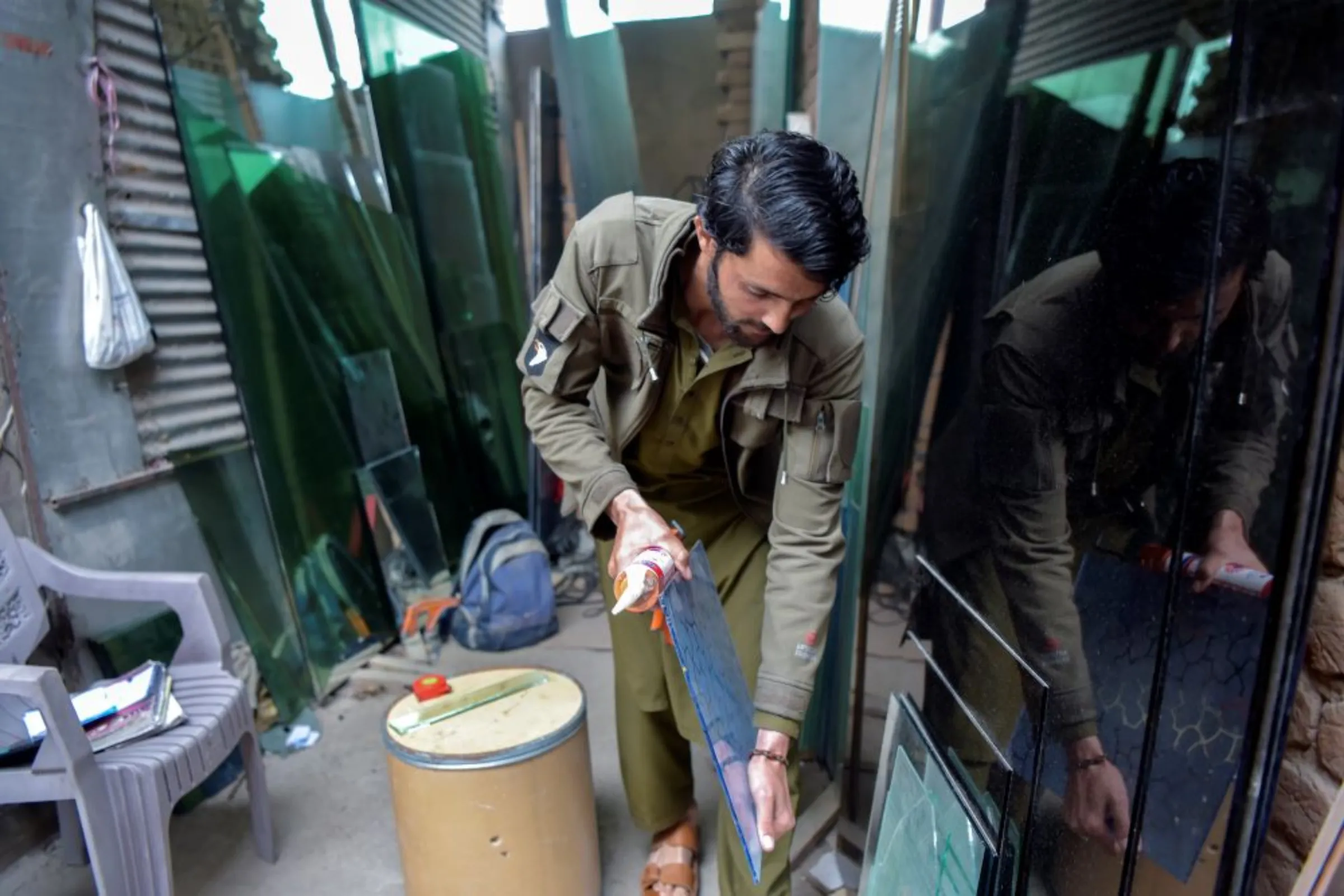 Afghan refugee, Khair Wali, puts a pane of glass away at a shop in Peshawar, Pakistan on March 8, 2022