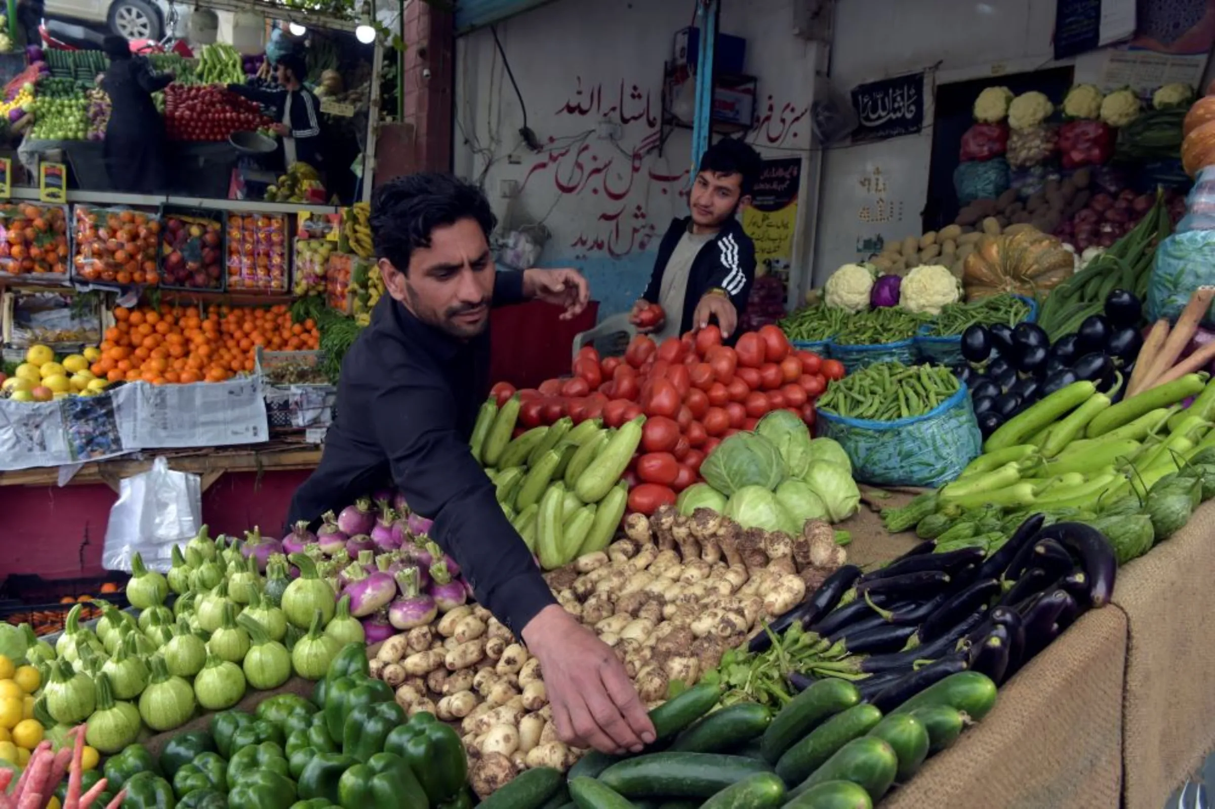 Afghan refugee, Masoom Jan, arranges vegetables at a shop in Peshawar, Pakistan on March 8, 2022