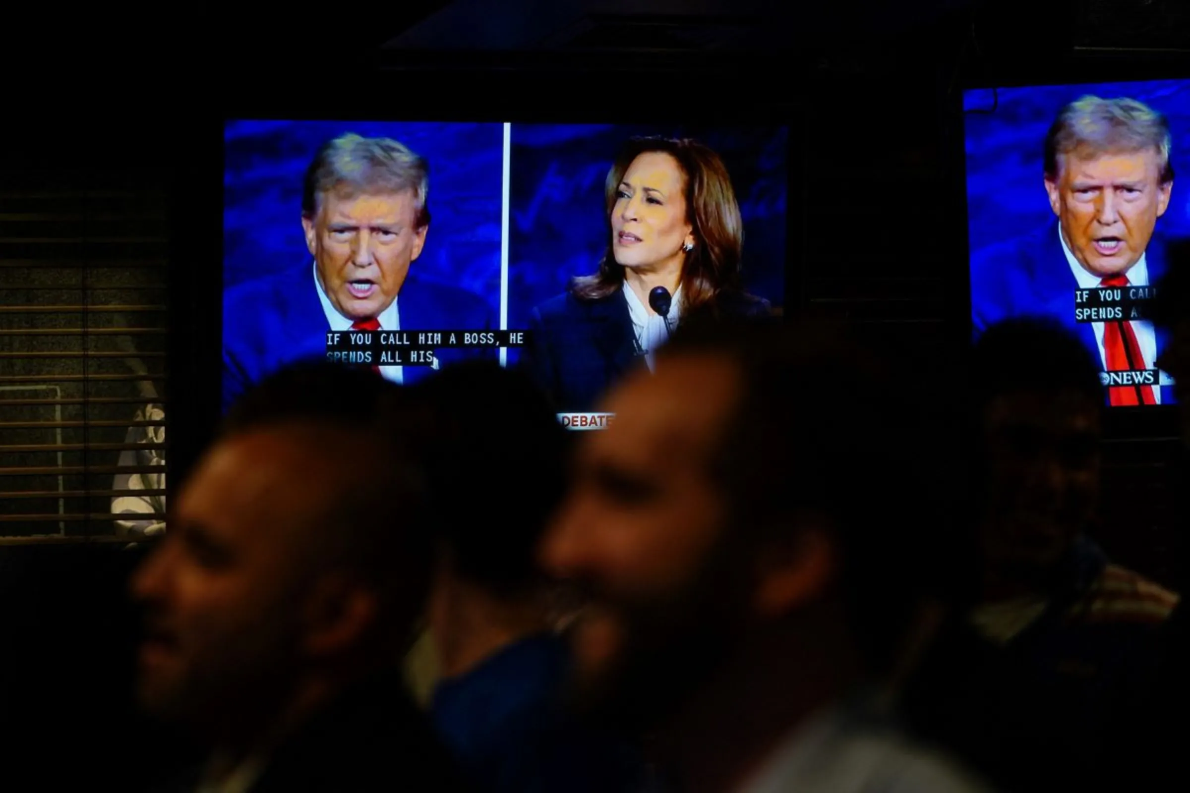 People watch the presidential debate between Republican presidential nominee Donald Trump and Democratic presidential nominee  U.S. Vice President Kamala Harris in New York City, U.S., September 10, 2024. REUTERS/Adam Gray