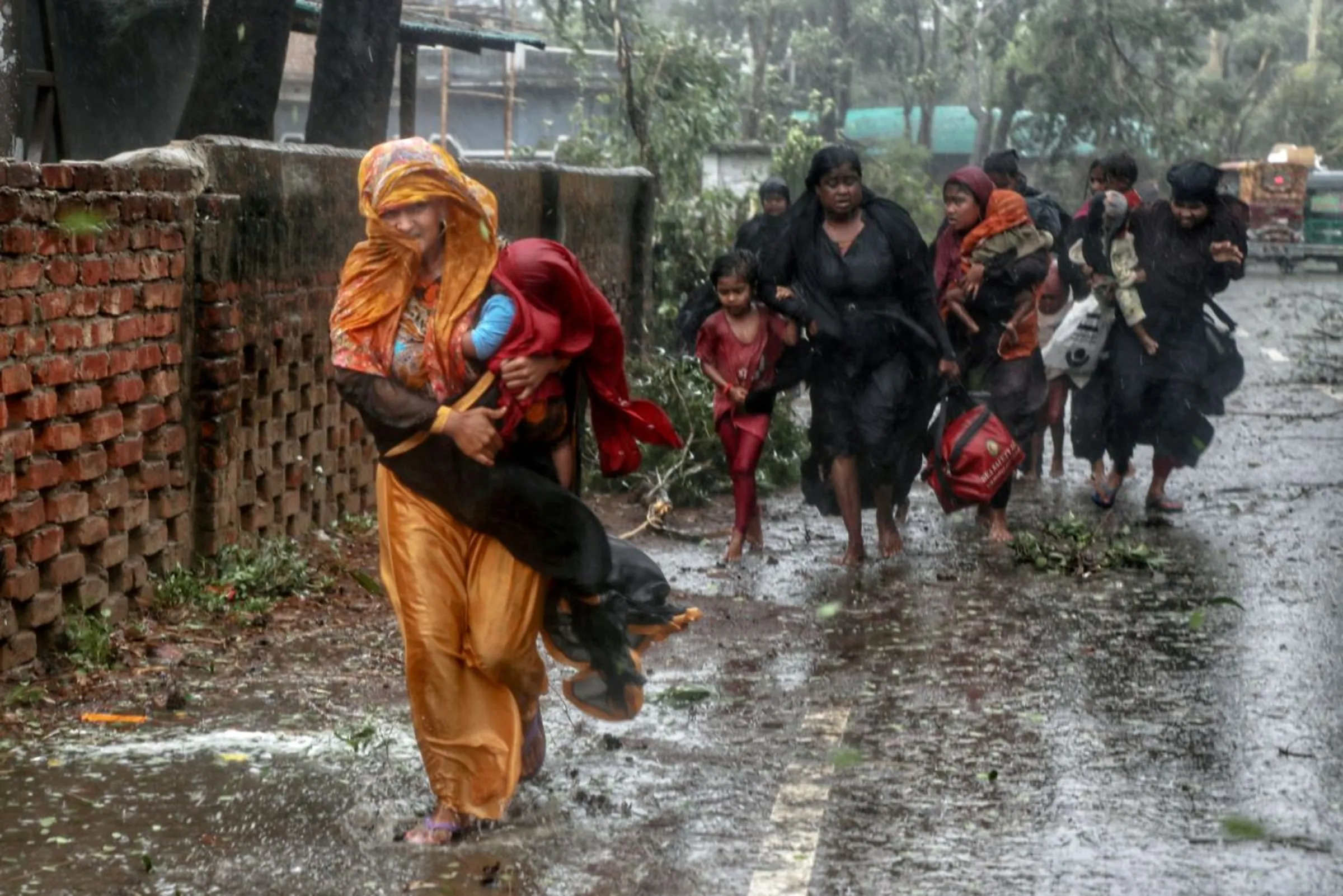 People move from their homes to take shelter in the nearest cyclone shelter at Shah Porir Dwip during the landfall of cyclone Mocha in Teknaf, Bangladesh, May 14, 2023