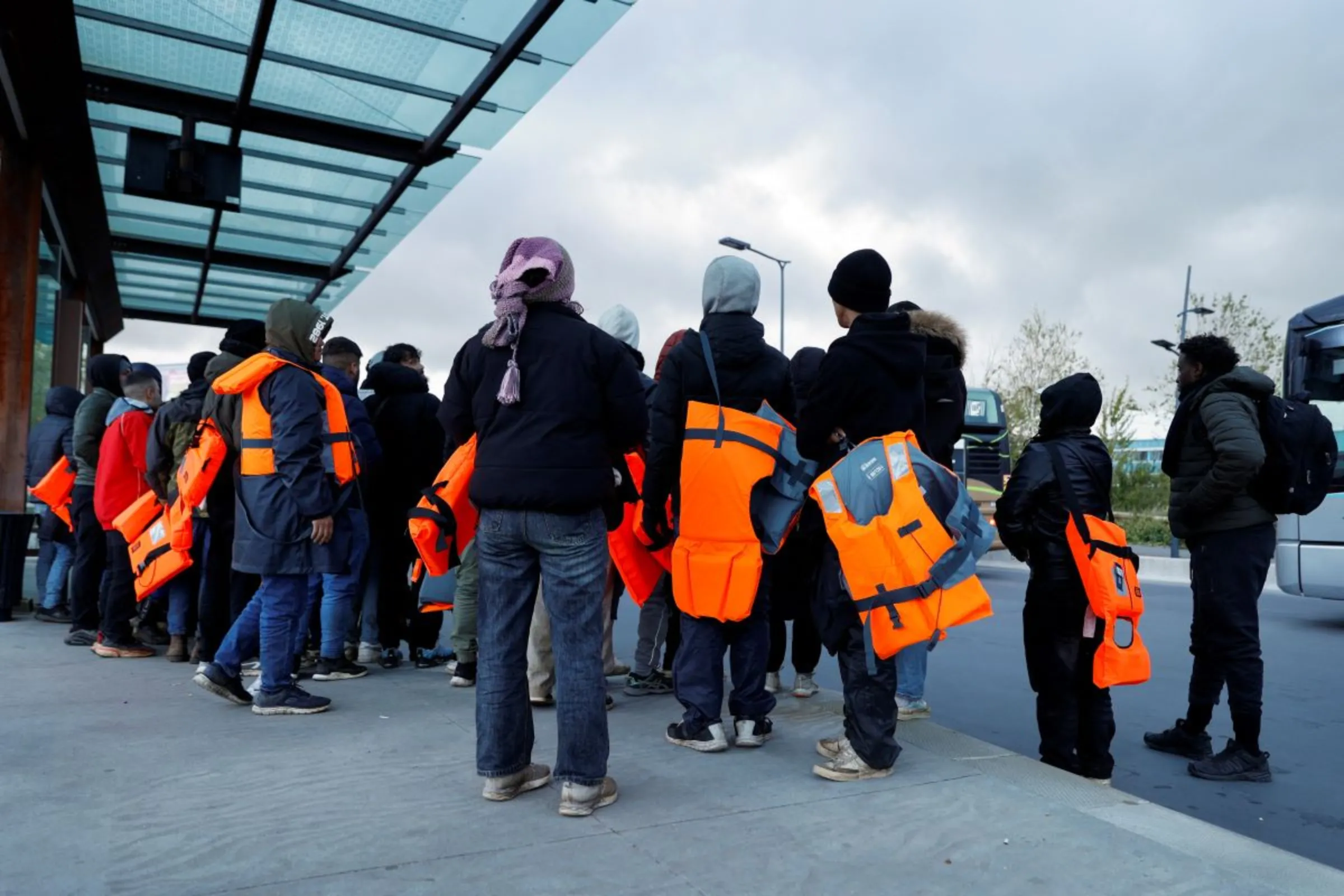 Migrants wait for a bus to return from the beach to their camp, at Calais train station, in Calais, France, April 23, 2024. REUTERS/Abdul Saboor