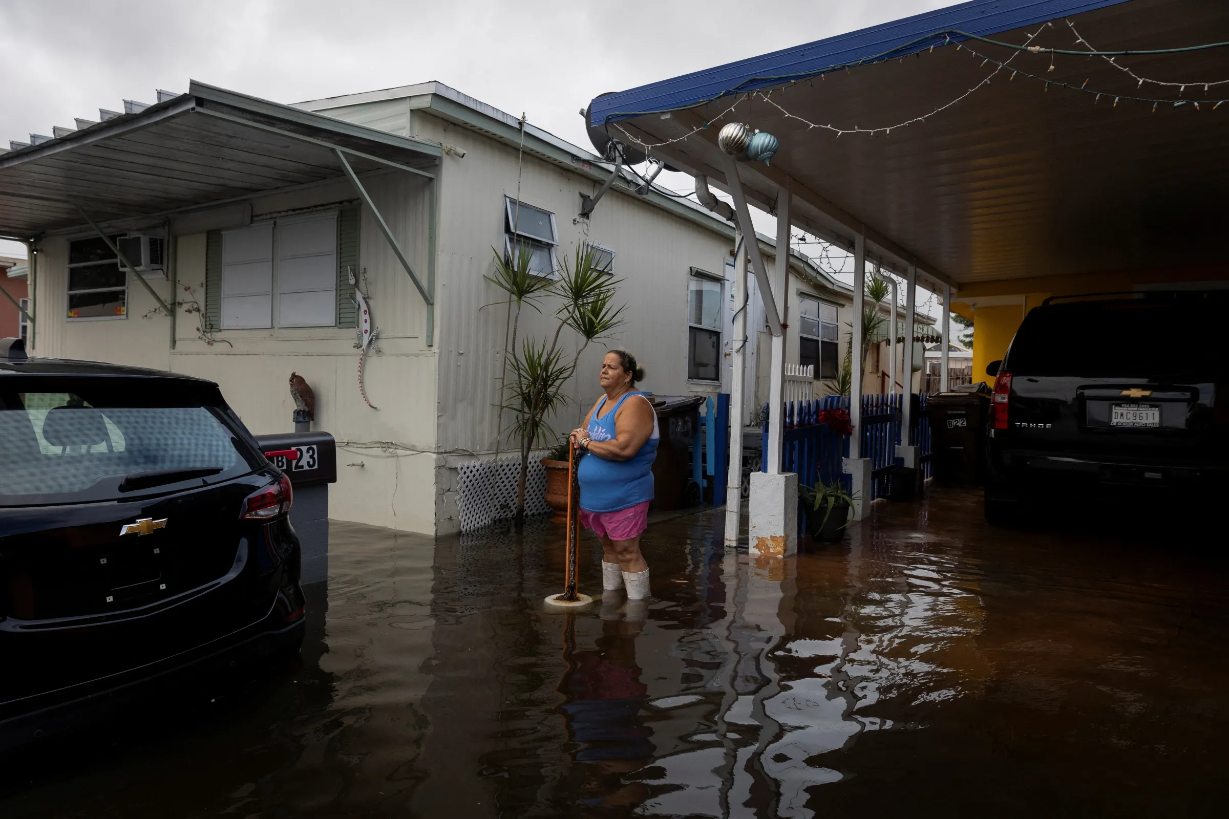 A woman looks at flood water from her house at a trailer park community in Hialeah, Florida, U.S., November 16, 2023. REUTERS/Marco Bello