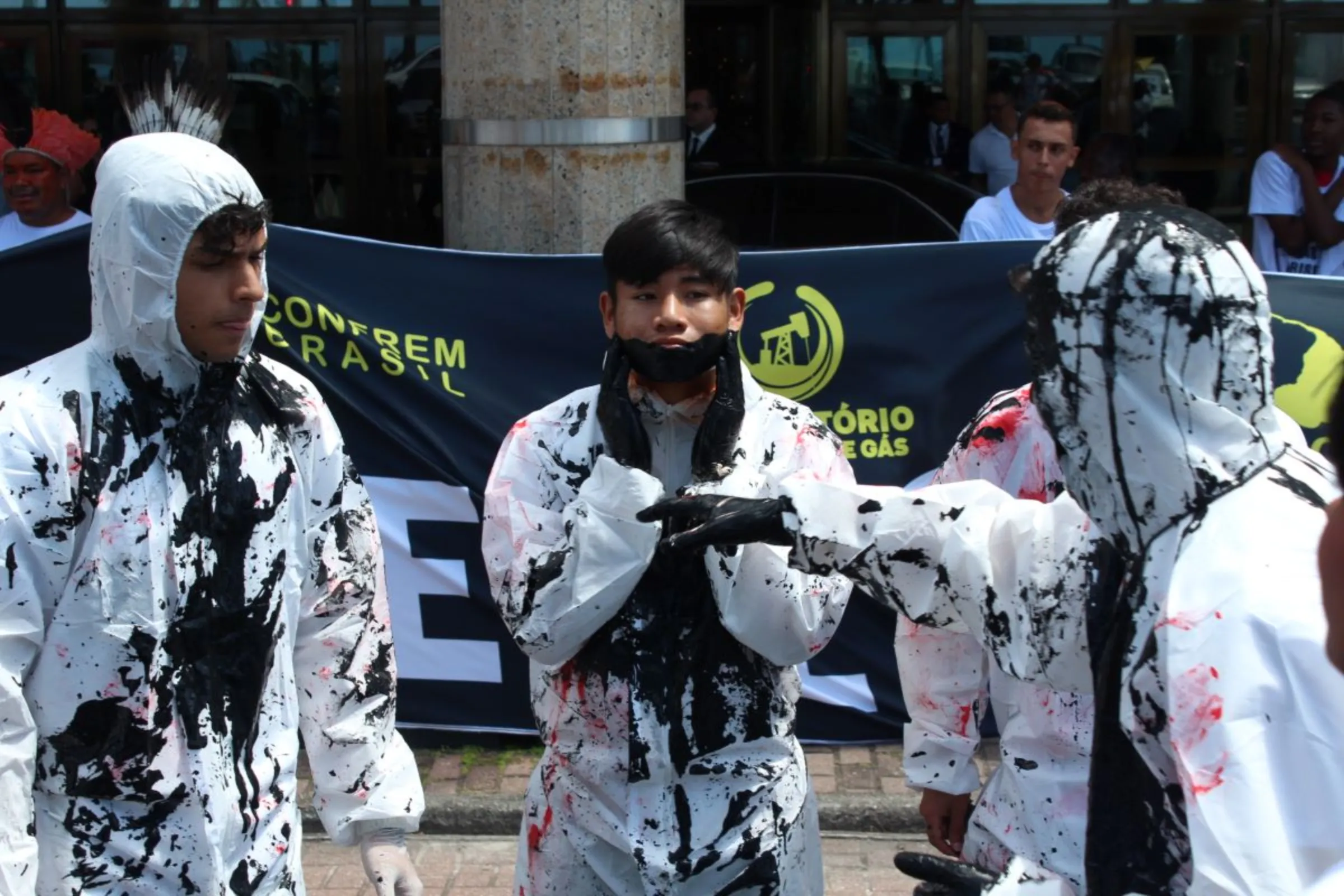 A protester with his face painted black stands in front of the hotel where Brazil’s government held an auction for oil and gas concession areas in Rio de Janeiro on Dec. 13, 2023. Thomson Reuters Foundation /André Cabette Fábio