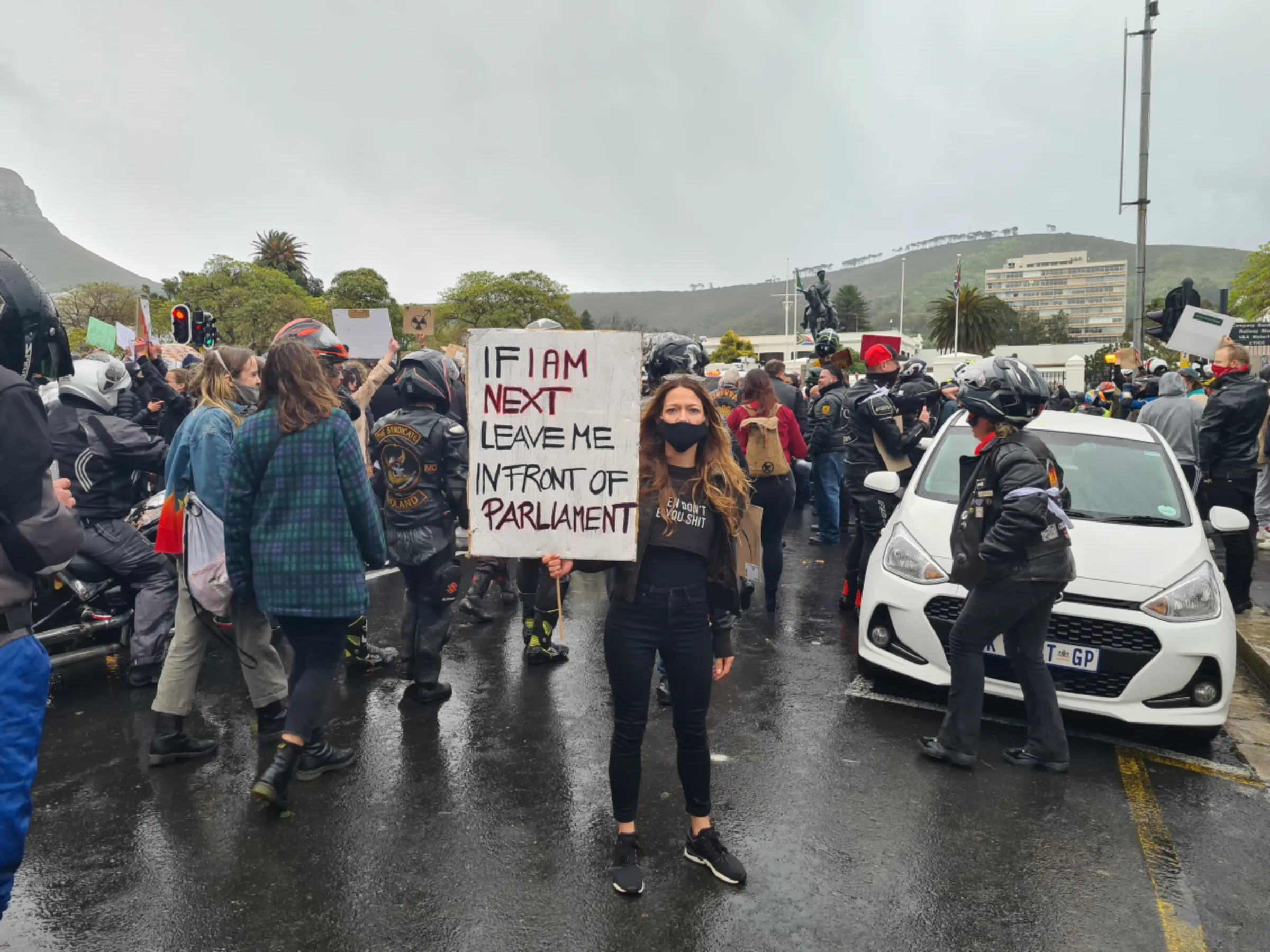 Sabrina Walter, founder of Women For Change, poses for a portrait as she holds up a sign at an anti-GBV Cape Town protest in South Africa, August 2021