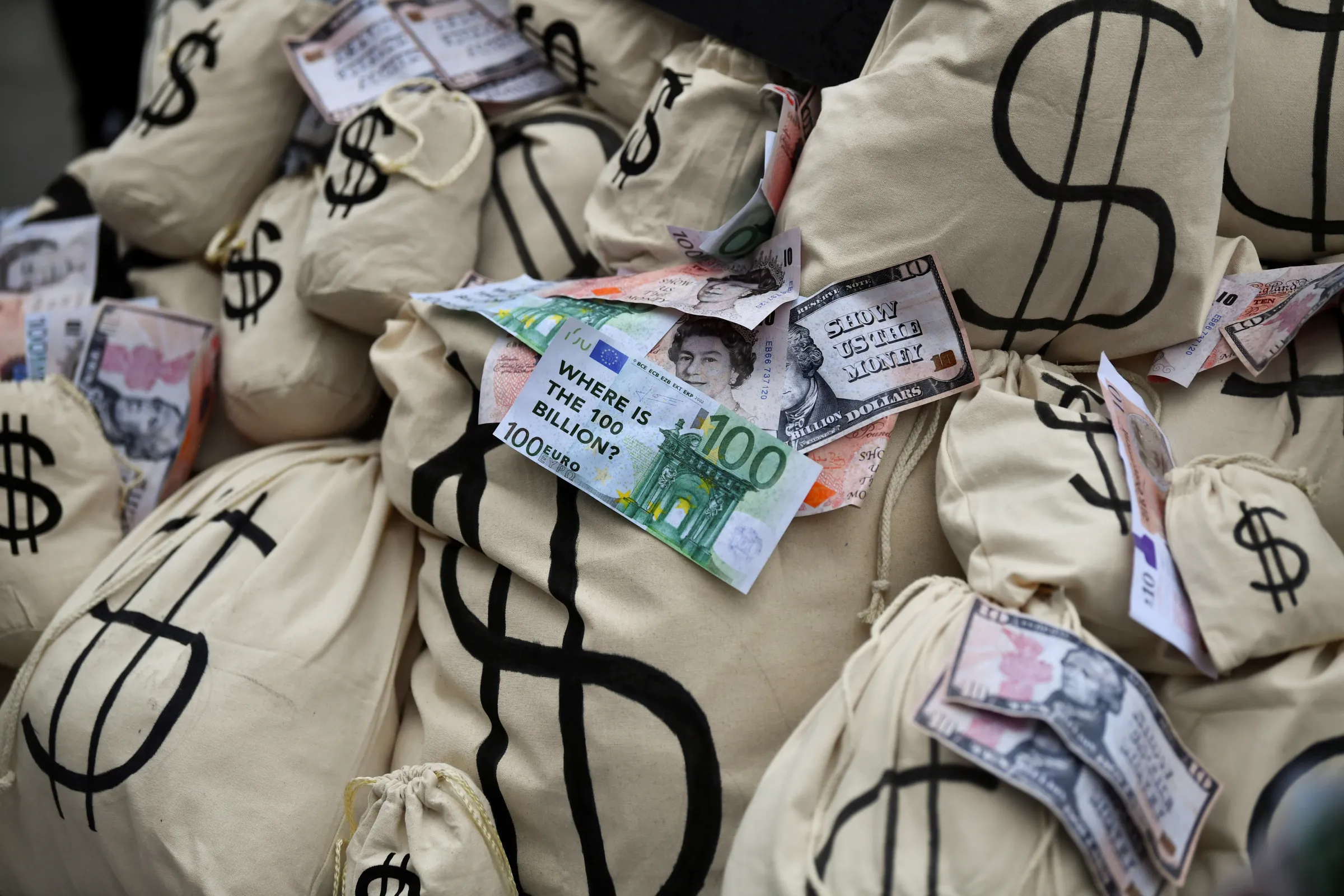 Mock money bags and banknotes are piled up during a protest at the UN Climate Change Conference (COP26) in Glasgow, Scotland, Britain November 12, 2021