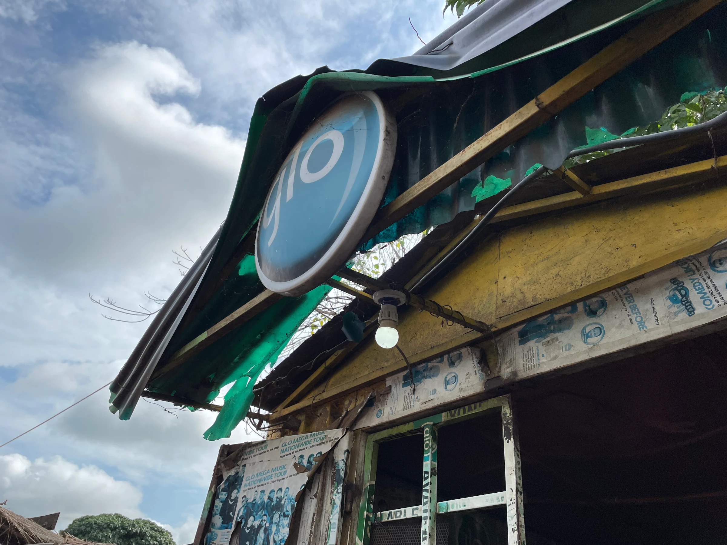 A solar-powered light bulb shines above the entrance to John Dauda Buhari's mobile-phone charging shop in Igbabo, Nasarawa, Nigeria, September 27, 2022. Thomson Reuters Foundation/Afolabi Sotunde