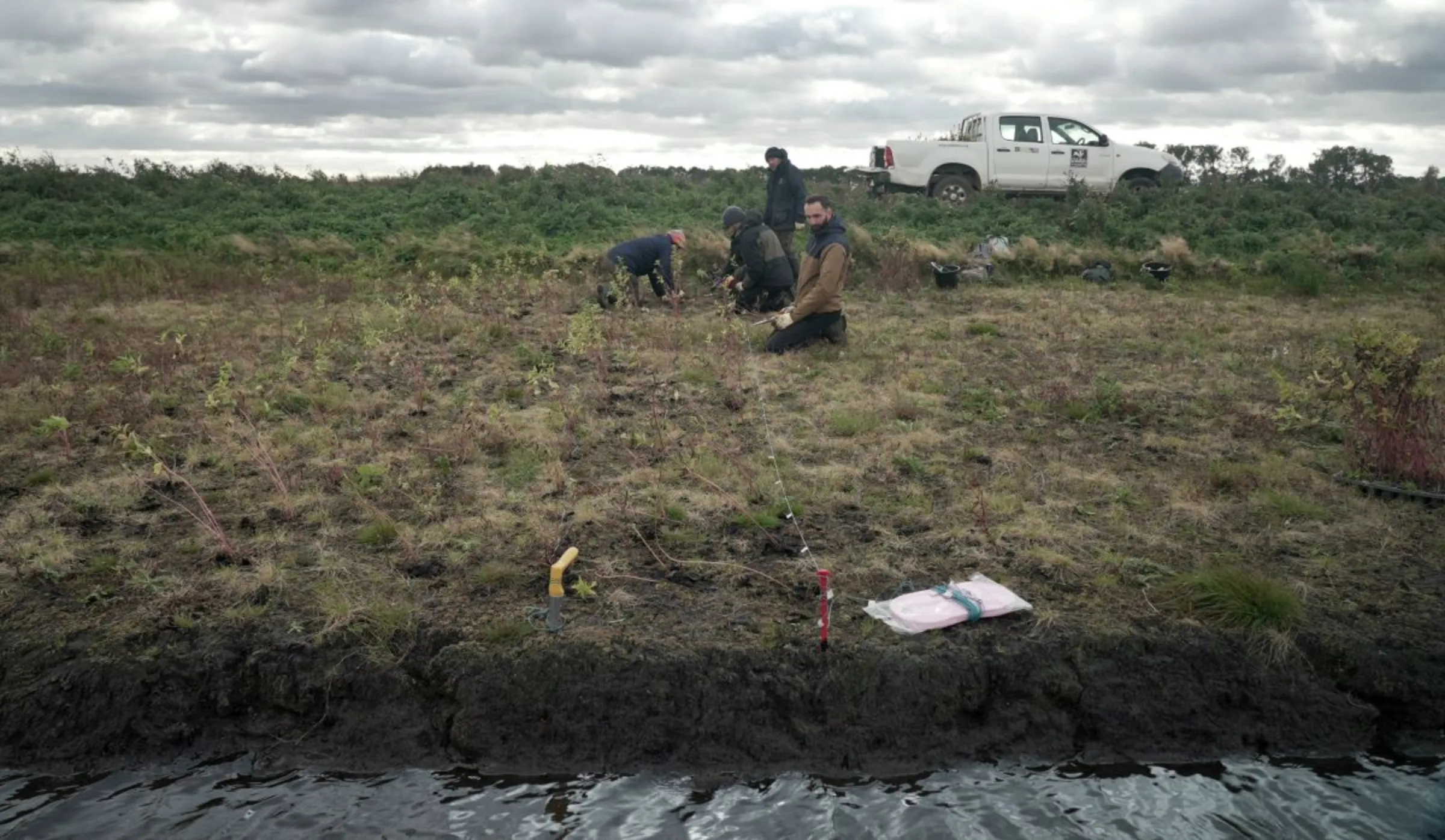 Volunteers from the Cambridgeshire Wildlife Trust’s Water Works project, plant crops suitable to waterlogged conditions in the peat-rich fields of the Fens near Holme, Britain, October 22, 2021. REUTERS/Natalie Thomas