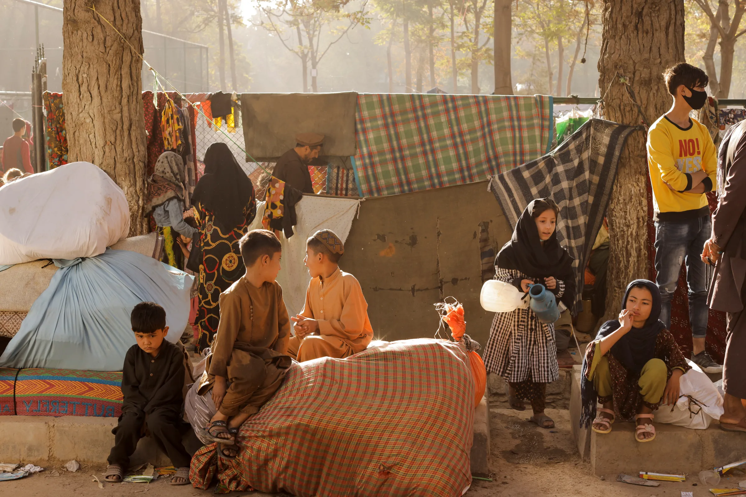 Afghan families, who are among displaced people fleeing the violence in their provinces, sit with their belongings as they prepare to return to their provinces, at a makeshift shelter at Shahr-e Naw park, in Kabul, Afghanistan October 4, 2021