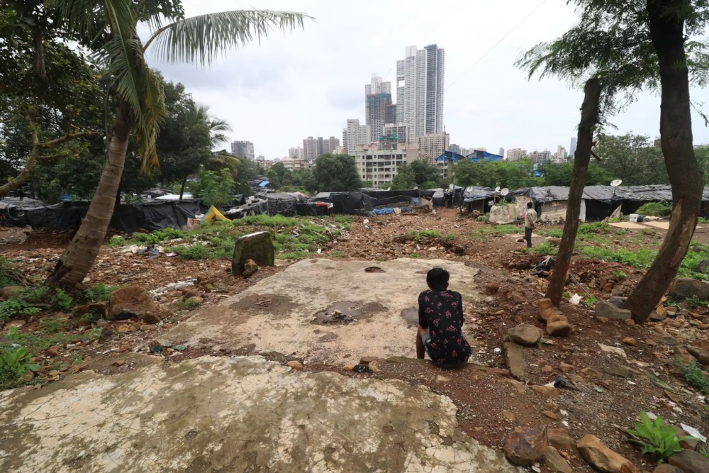 A man sits at the site of a house destroyed in Ambedkar Nagar slum after a retaining wall of a water reservoir collapsed in 2019 during heavy rains in Mumbai, India, September 6, 2021