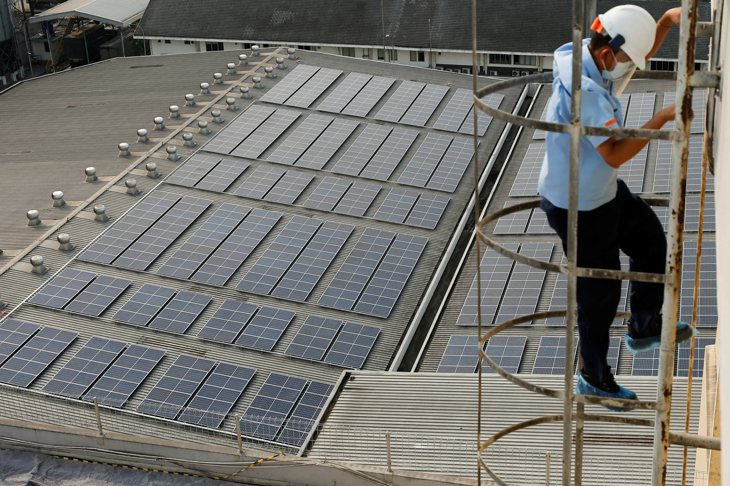 An engineer goes down a ladder after checking the electrical power from the solar panels that are installed on the roof of Bogasari Flour Mills factory in Bekasi, West Java province, Indonesia, September 15, 2022. REUTERS/Willy Kurniawan