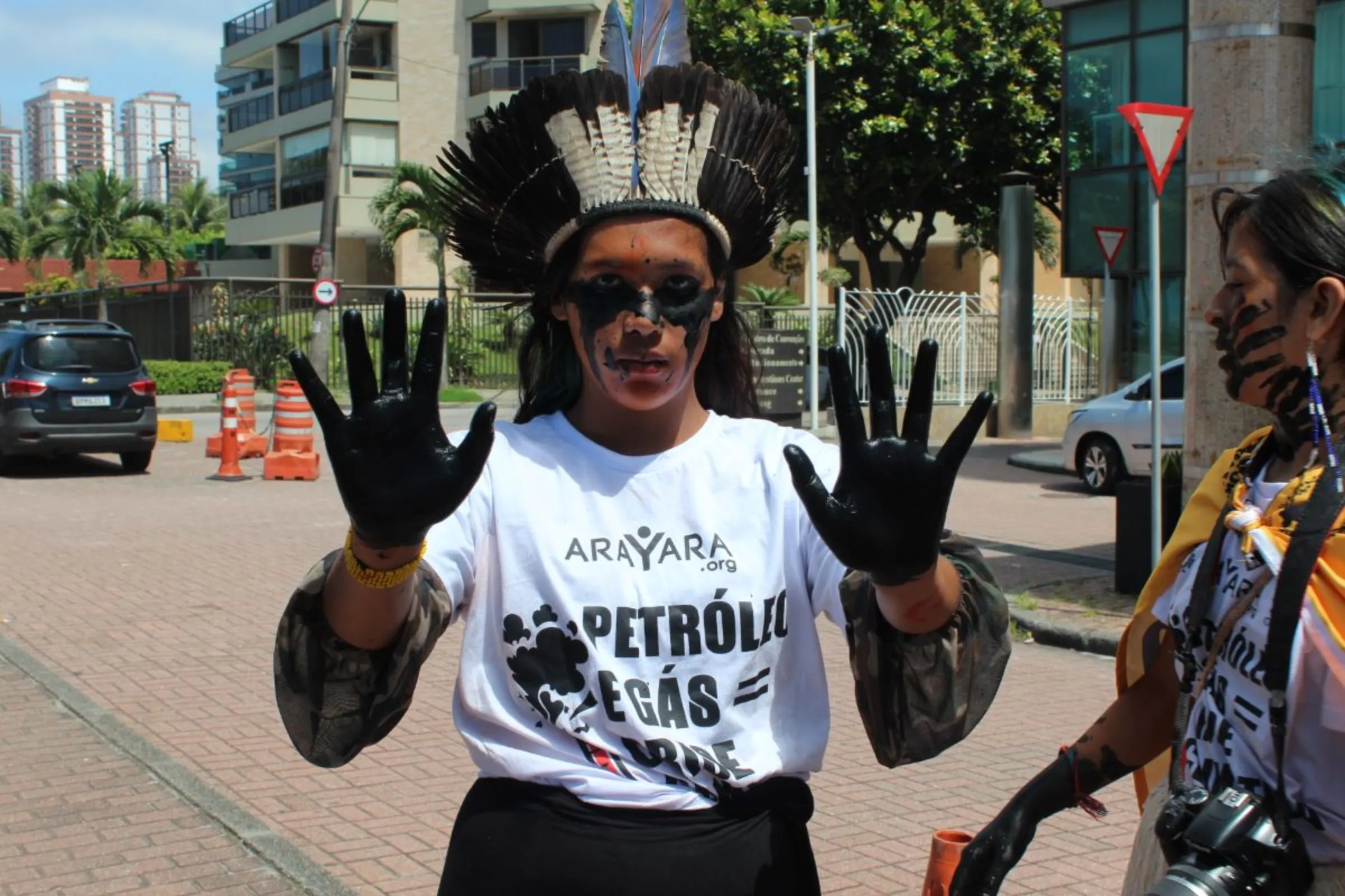 A protester shows their hands painted black in front of the hotel where Brazil’s government held an auction for oil and gas concession areas in Rio de Janeiro on Dec. 13, 2023. Thomson Reuters Foundation /André Cabette Fábio