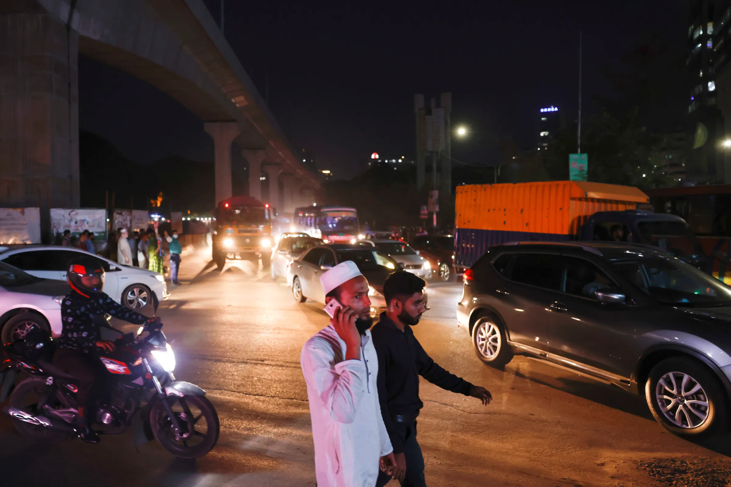 A man talks on his phone while crossing a road at night, in Dhaka, Bangladesh, May 22, 2022. REUTERS/Mohammad Ponir Hossain