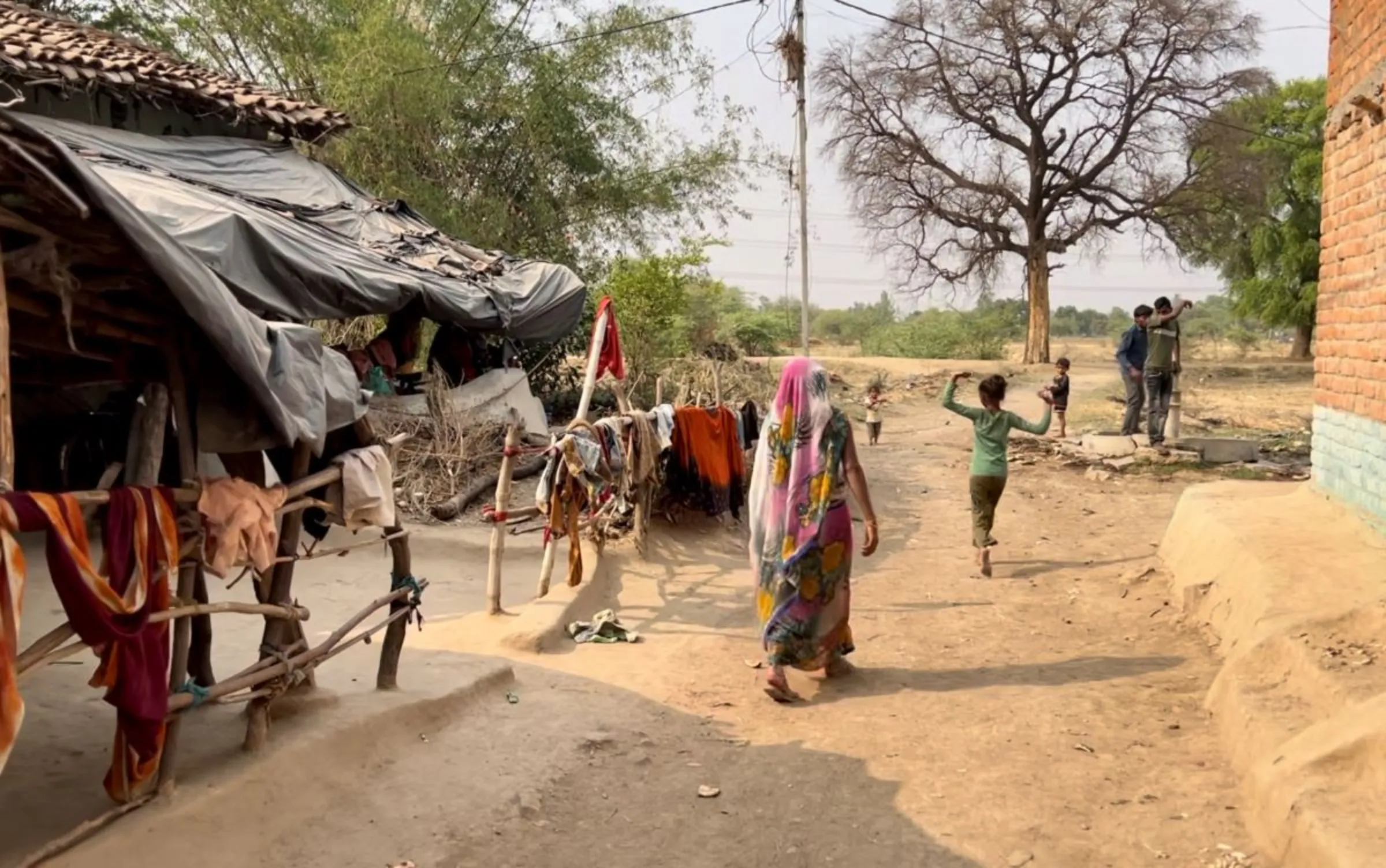 A woman follows her daughter in Raja Ram Ka Purva village, Banda, India, May 15, 2024. Thomson Reuters Foundation/Bhasker Tripathi